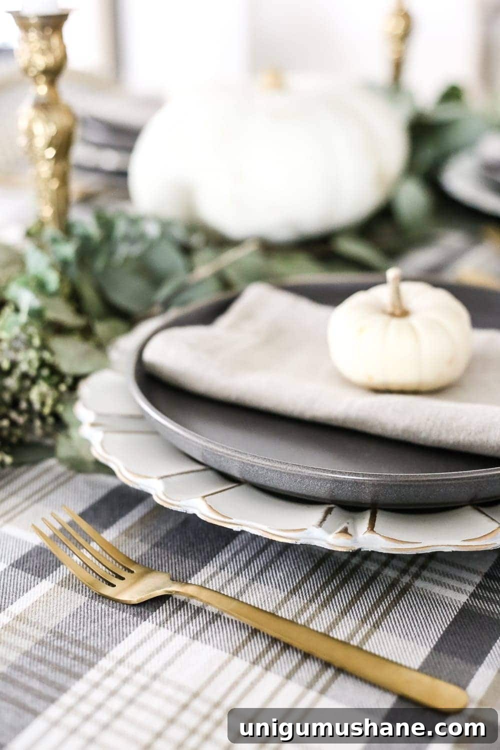 Neutral Thanksgiving Tablescape Ideas for an Understated Fall Table 7 Neutral Low-Key Thanksgiving Tablescape | blesserhouse.com - A neutral low-key Thanksgiving tablescape that is simple and inexpensive to recreate using plaid fabric, white pumpkins, eucalyptus, and brass.