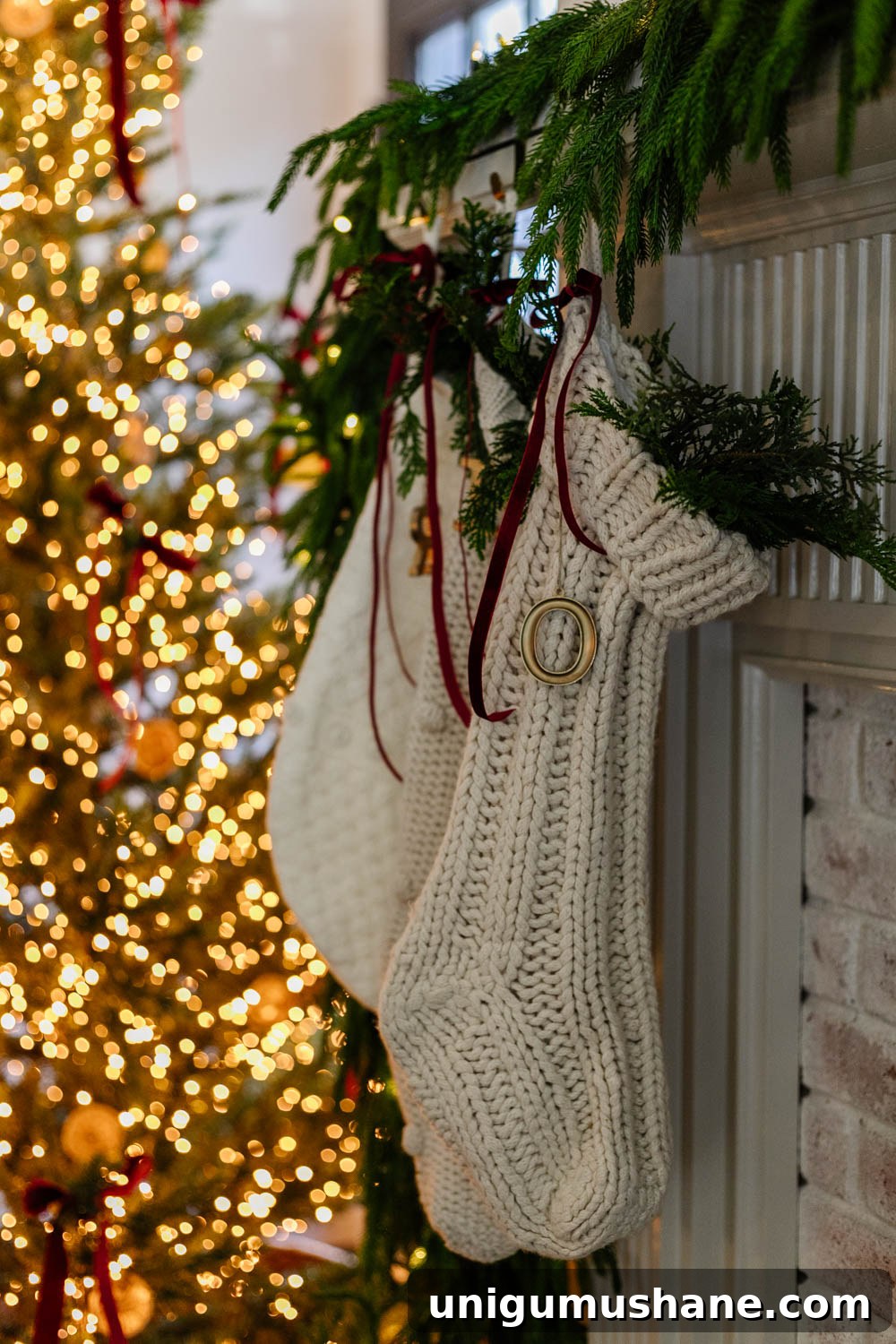 250 Stocking Stuffer Ideas for Families in 2025 3 christmas stockings on a mantel with red ribbon