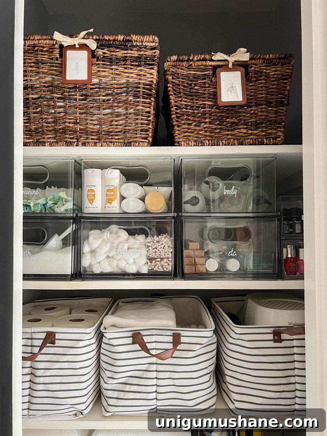 pair of baskets storing bedsheets and clear bins storing soaps and toiletries