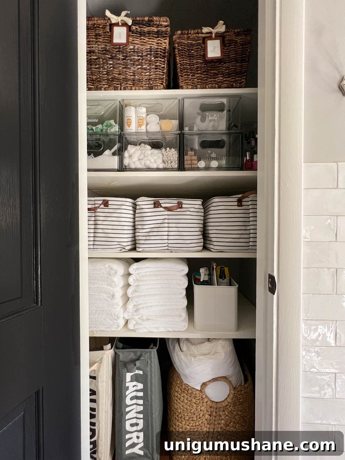 bathroom linen closet organized with bins, baskets, and storage drawers