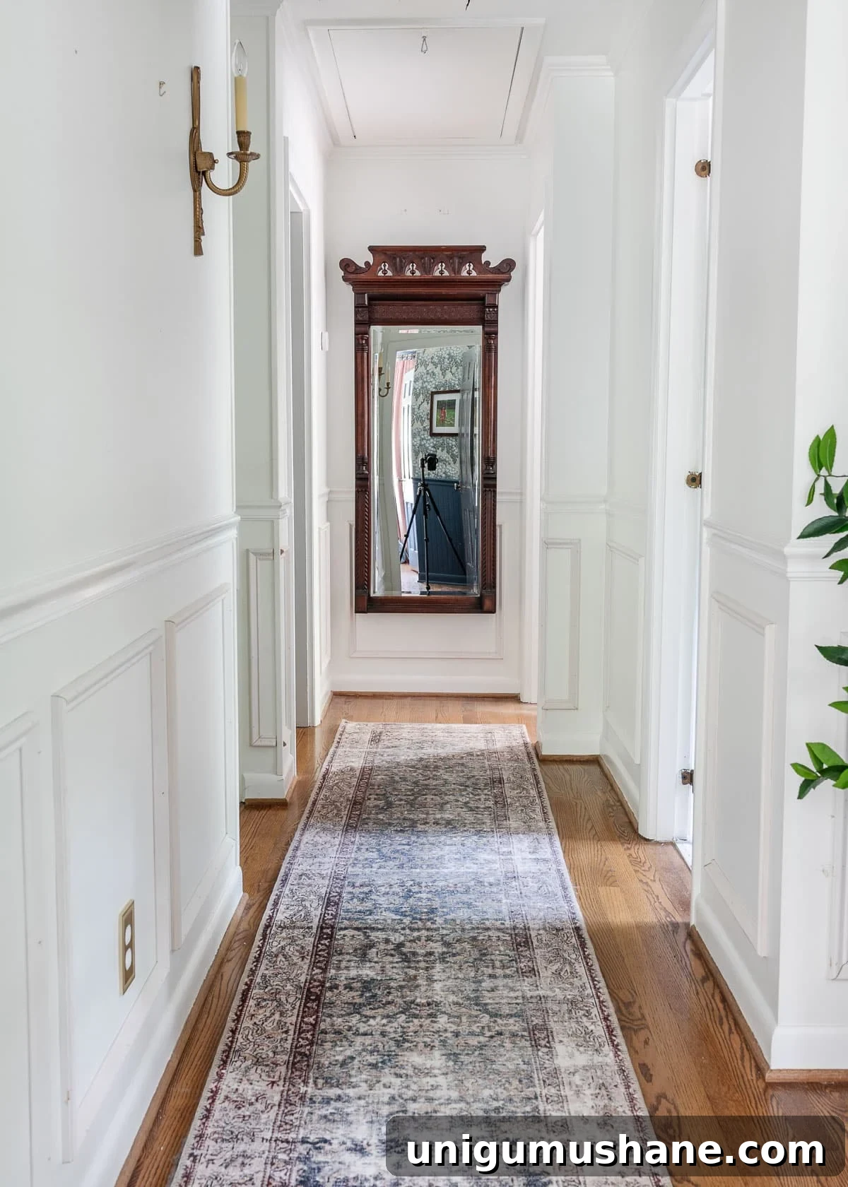 How to Hide a Thermostat Without Compromising Performance 2 white hallway with wood floors and mirror