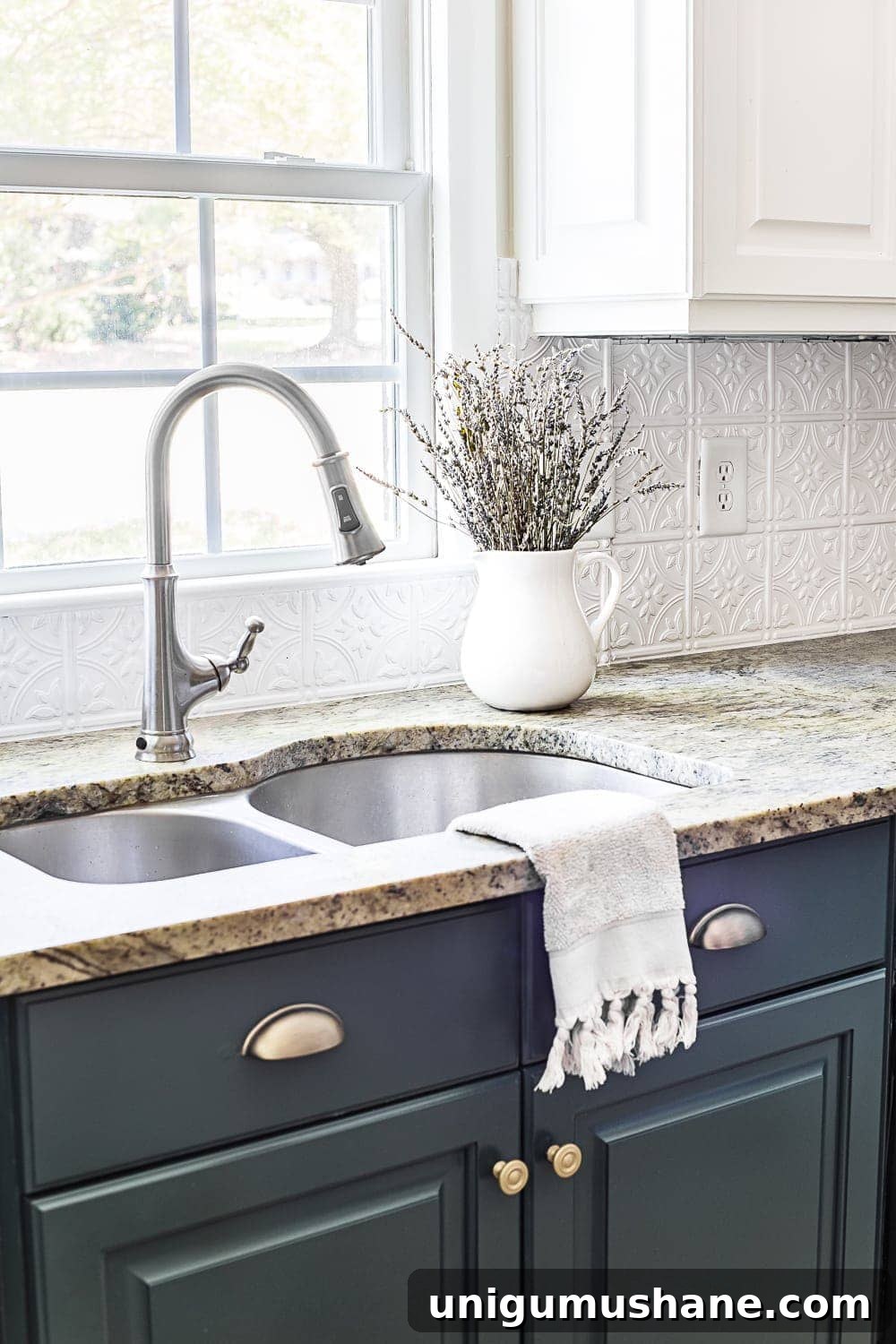 Pressed tin ceiling tile backsplash and deep green kitchen cabinets