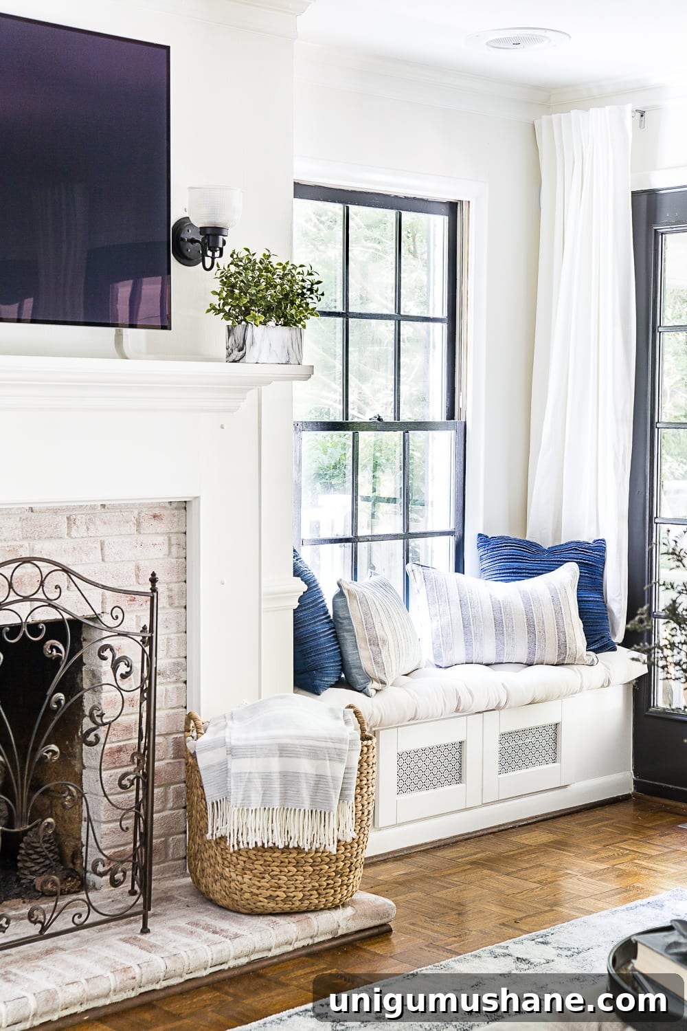 23 Small Room Tricks That Make Any Space Look Bigger 7 living room with window seat for electronics storage and limewashed fireplace