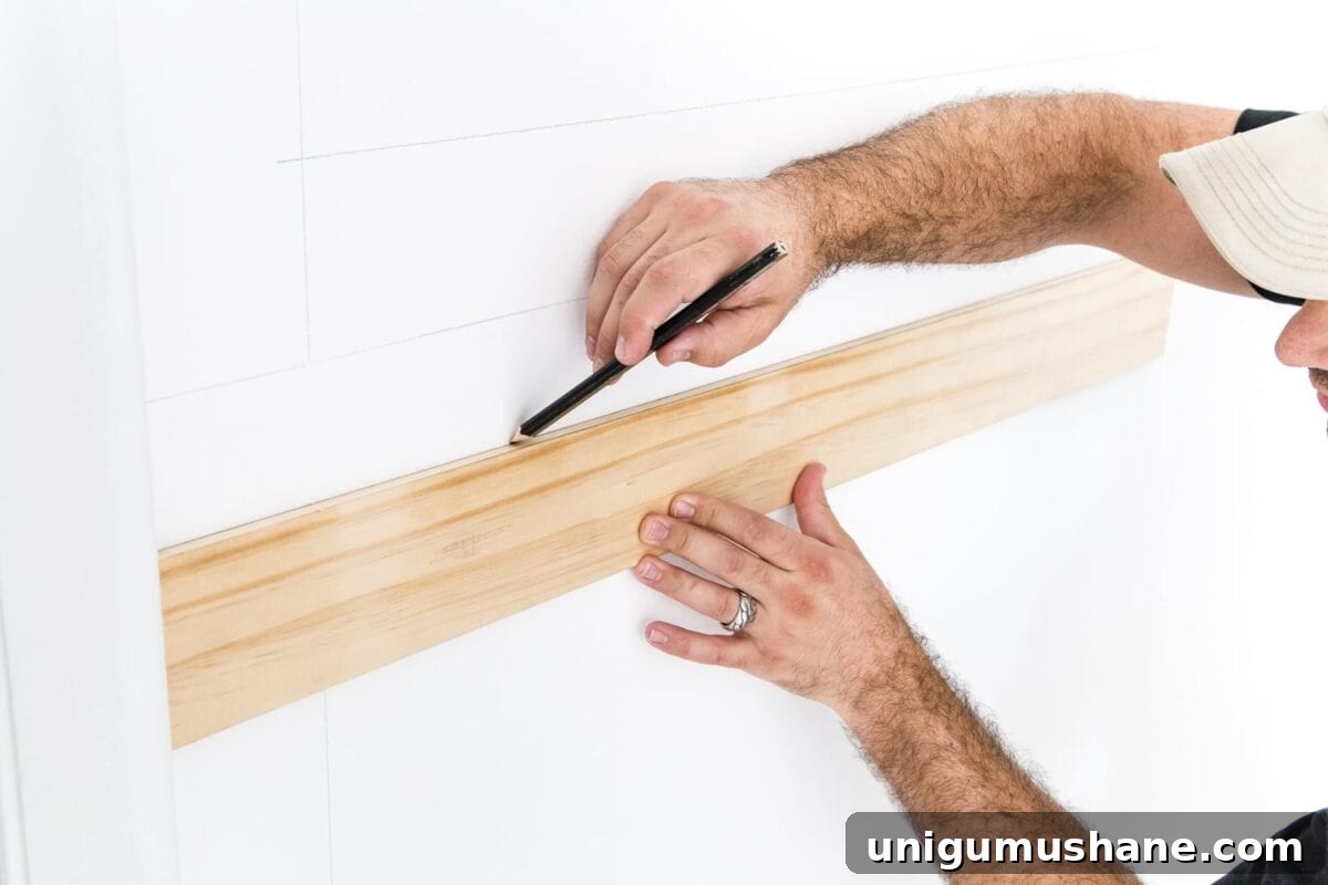Use a 3/8" x 4" board as a spacer to mark picture frame molding