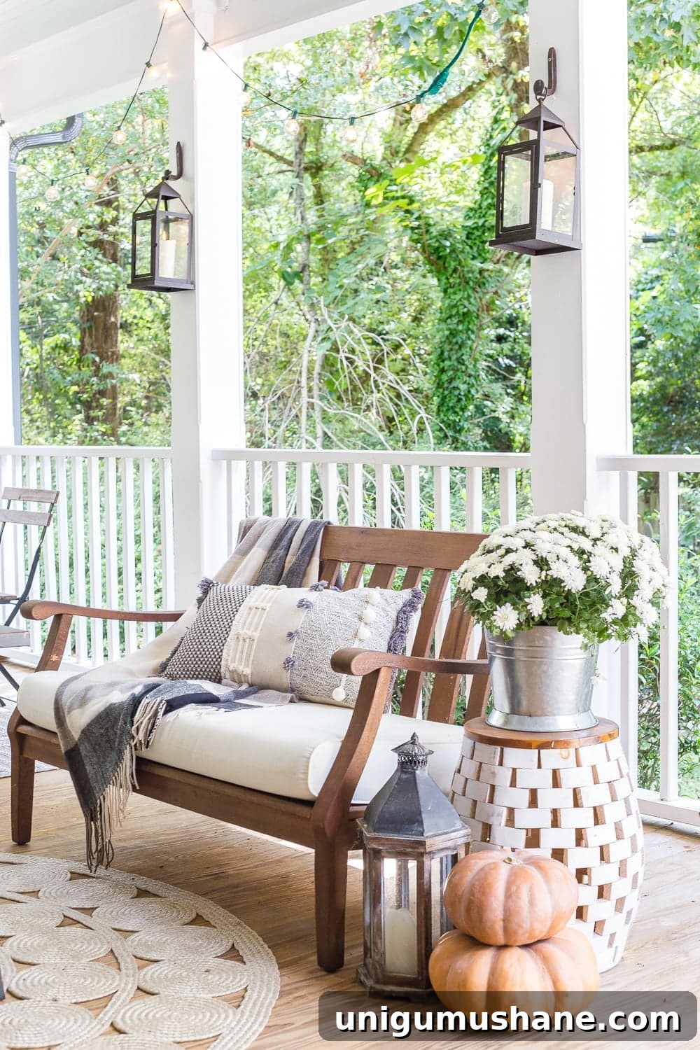 Fall Porch Tour and Cozy Outdoor Decor Ideas 11 cozy fall porch with plaid throw blankets, textured pillows, pumpkins, lanterns, mums, and string lights