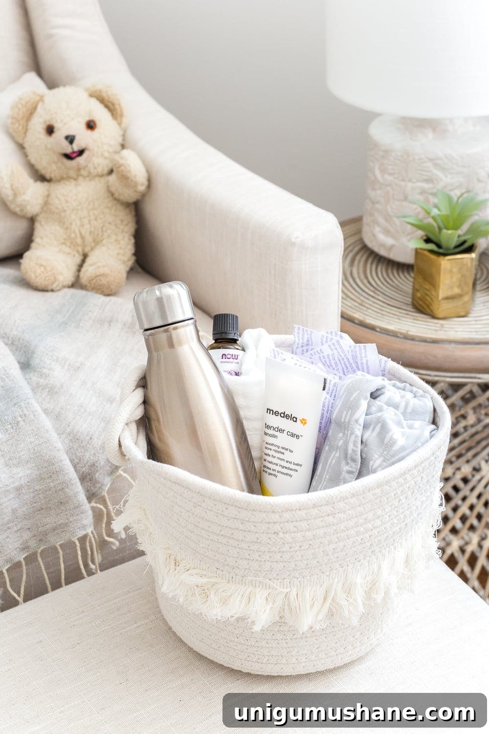 Nursery Organization Tour: Baby Room Storage and Layout 26 Nursery Organization | Breastfeeding basket to keep beside a chair filled with nursing pads, water bottle, lanolin, burp cloths, nursing cover, and lavender essential oil.
