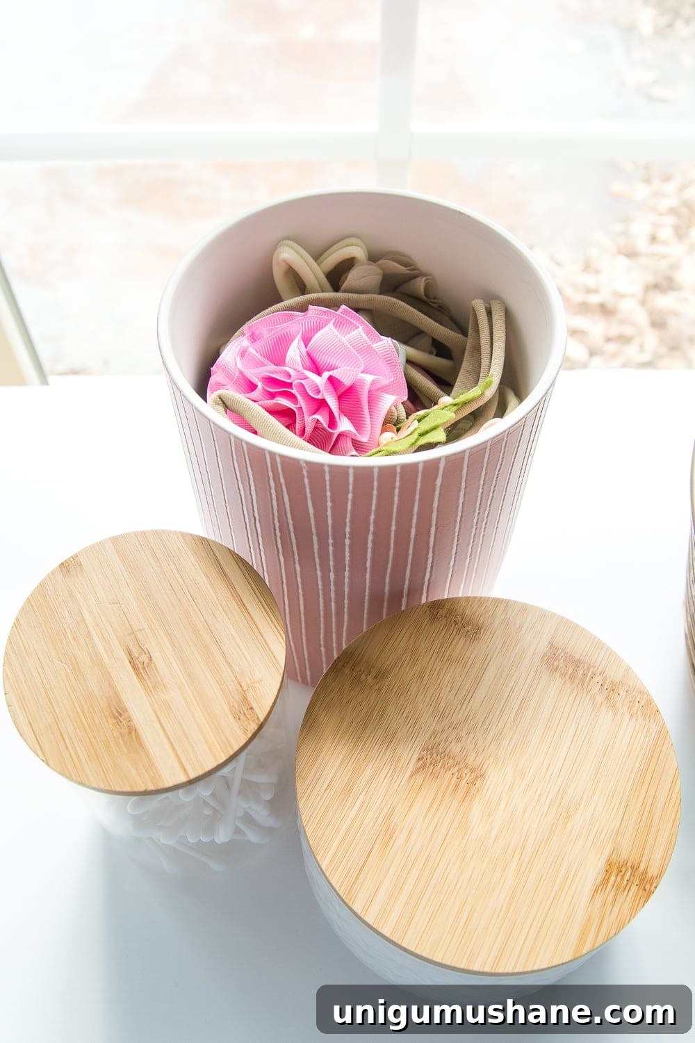 Nursery Organization Tour: Baby Room Storage and Layout 5 Nursery Organization | Use lidded canisters from the kitchenware aisle to store headbands and bows.