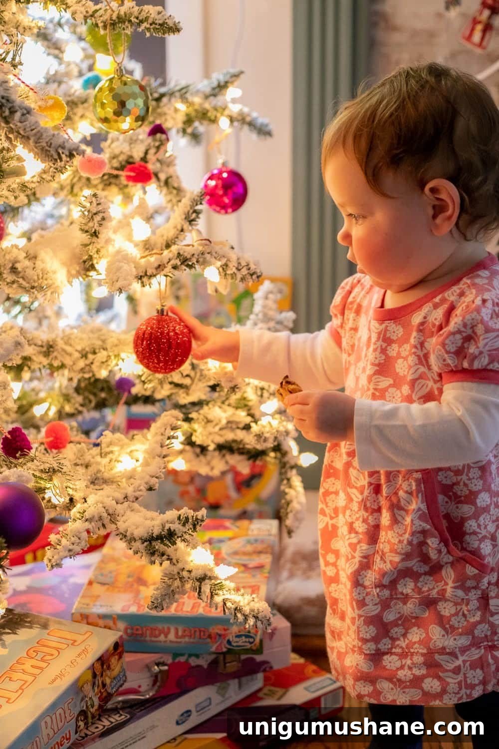 20 DIY Family Christmas Photo Ideas to Capture at Home 6 toddler standing beside a Christmas tree