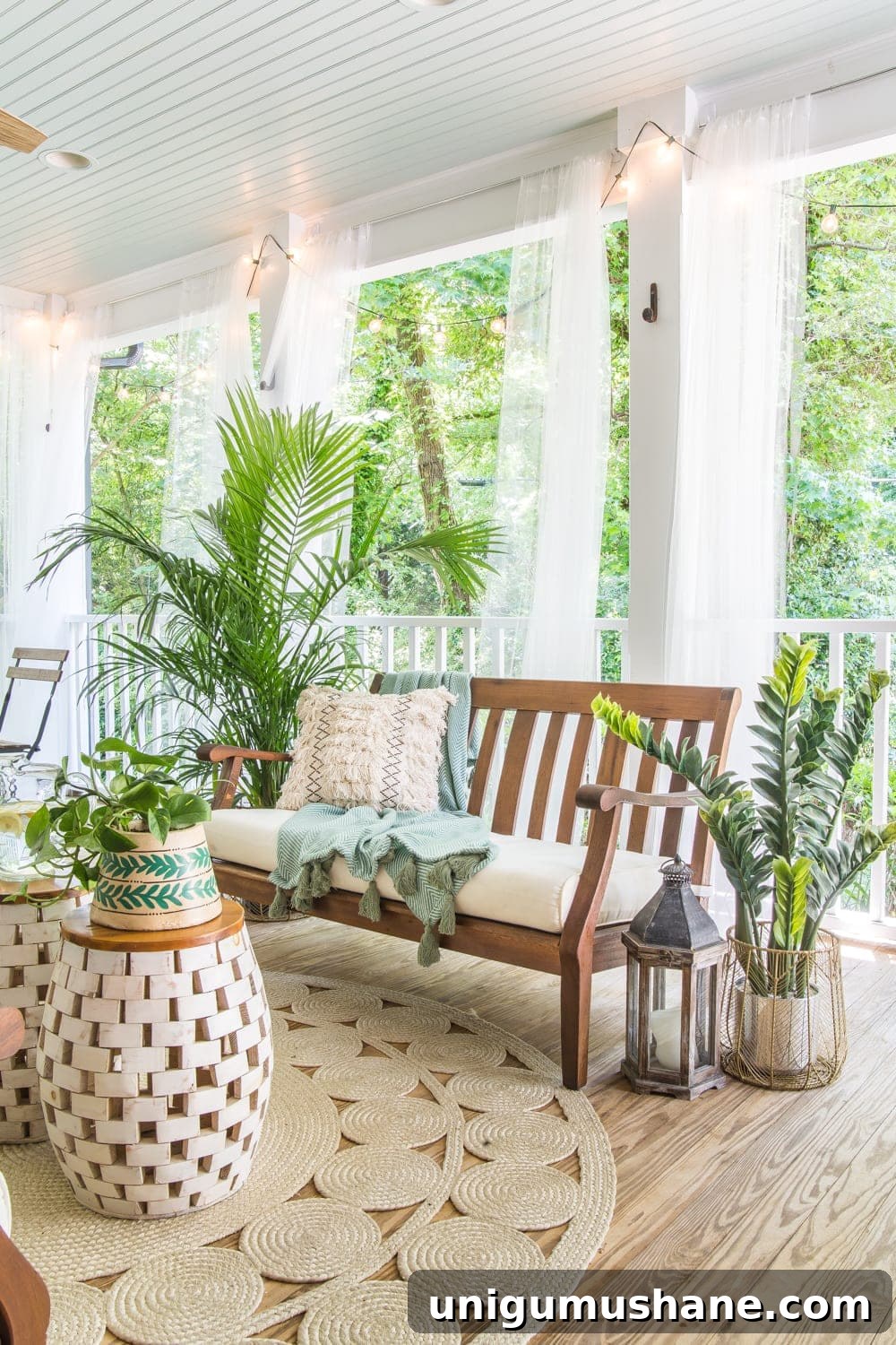 Boho Summer Back Porch Makeover Ideas 13 A tropical boho back porch decorated for summer with breezy, functional style from Flower Home and string lights for evening ambience.