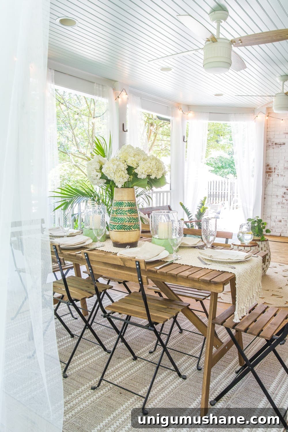 Boho Summer Back Porch Makeover Ideas 10 A tropical boho back porch decorated for summer with breezy, functional style from Flower Home and string lights for evening ambience.