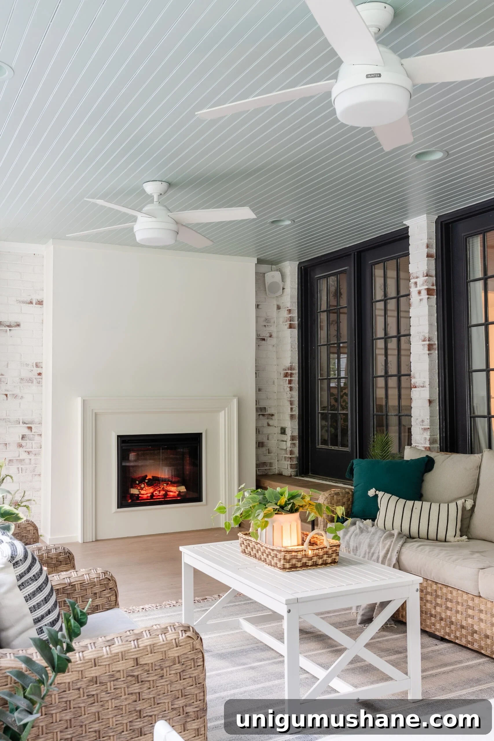 20 Modern Ceiling Fans to Transform Your Space 7 white outdoor ceiling fans on a porch with haint blue ceiling and limewash fireplace