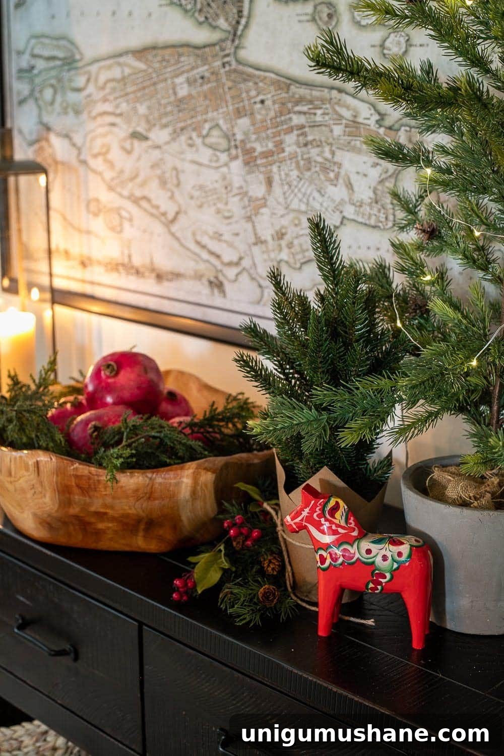 Mix Sentimental Heirlooms with New Decor for a Swedish Christmas 12 Swedish Christmas vignette with candlelight, Dala horse, bowl of pomegranates, greenery, and twinkle lights for hygge