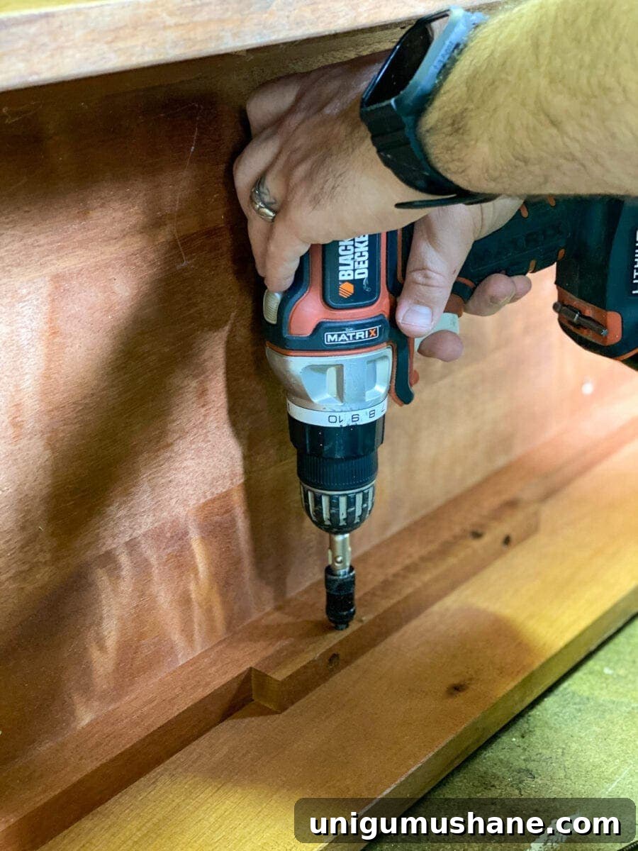 How to Refinish a Footed Grasscloth Buffet 3 Footed Grasscloth Buffet Makeover - Removing the bottom board to add decorative feet