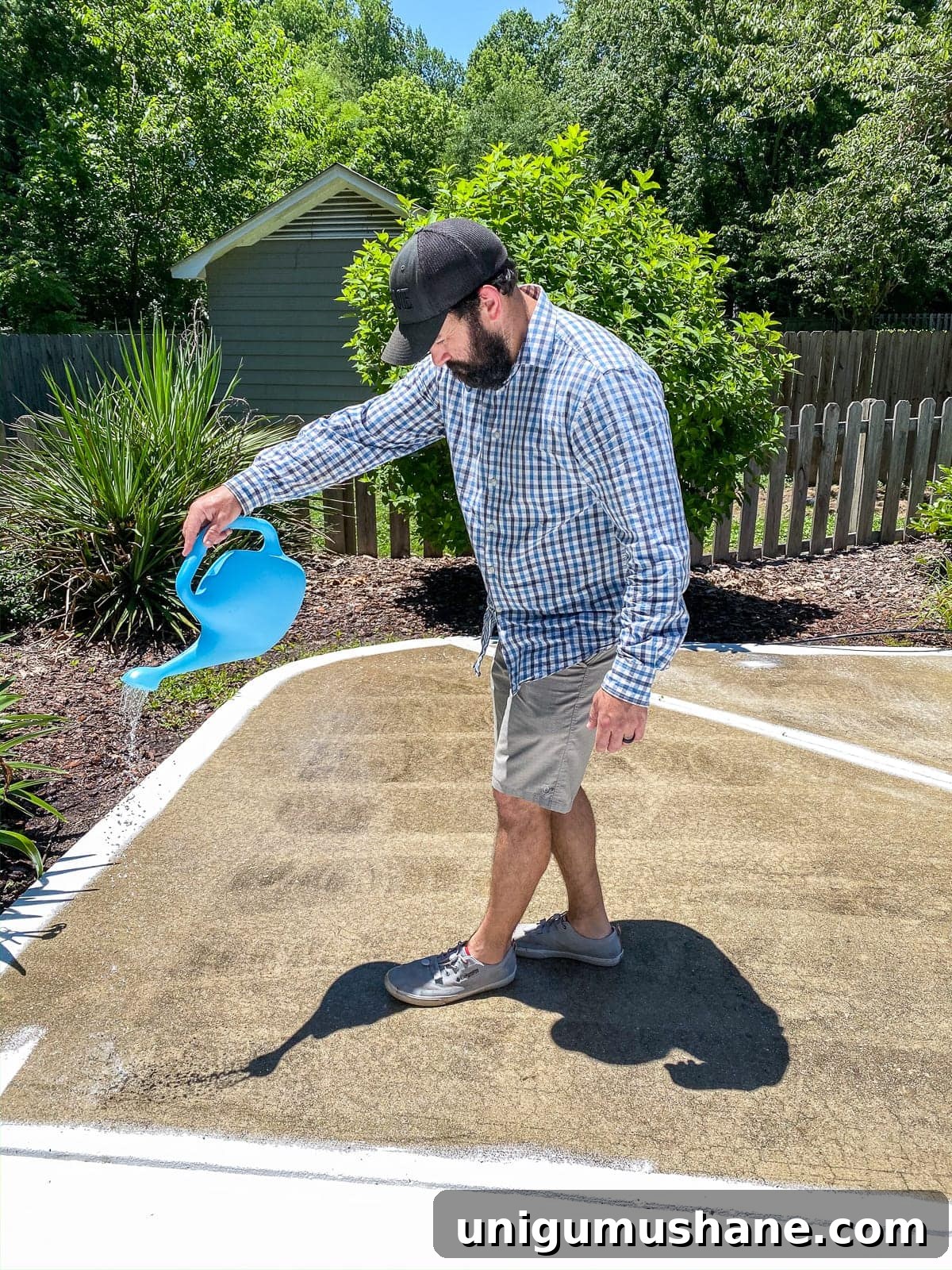 applying concrete etcher and cleaner with a watering can