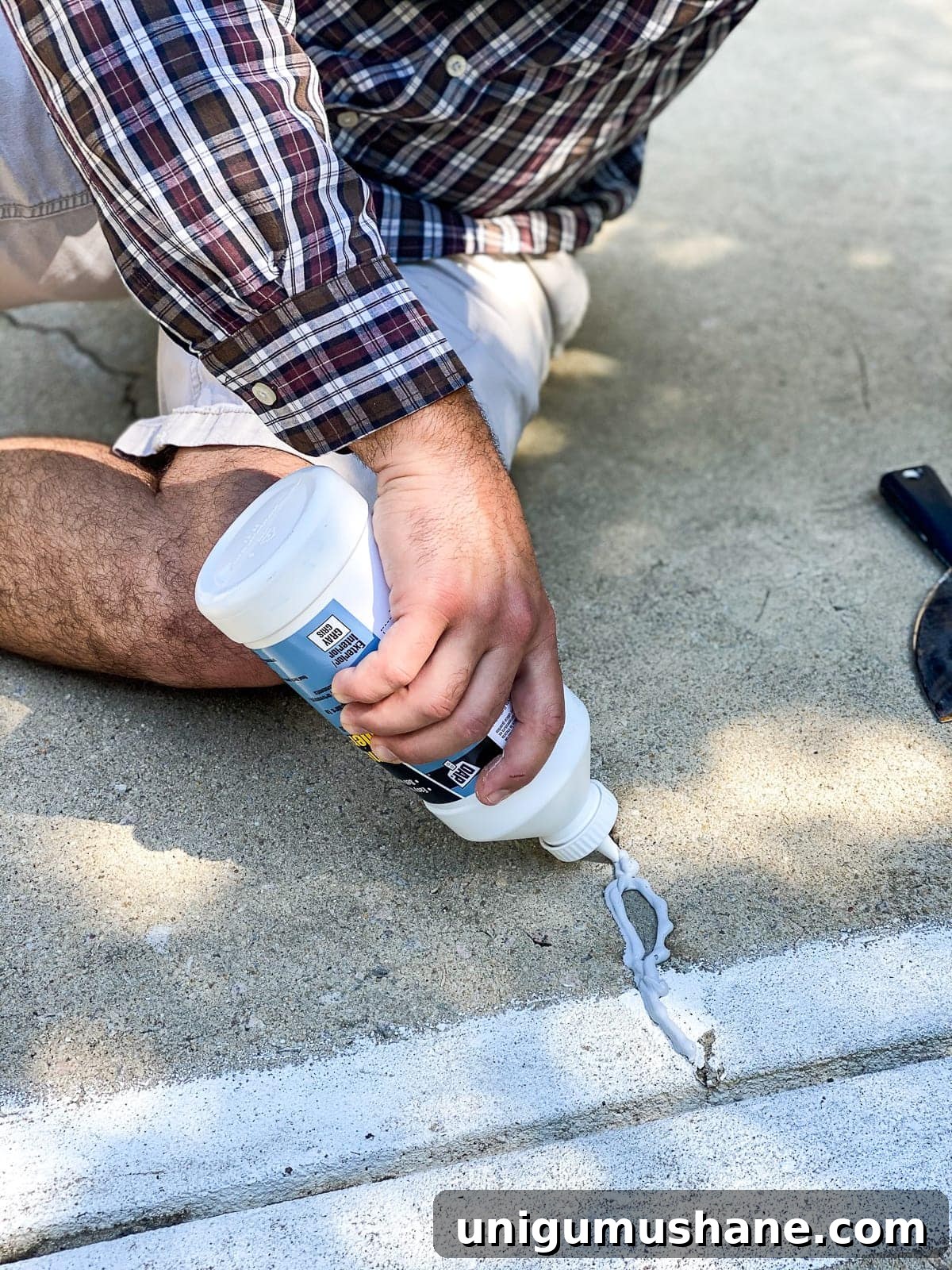 applying concrete filler to fill cracks and holes before painting