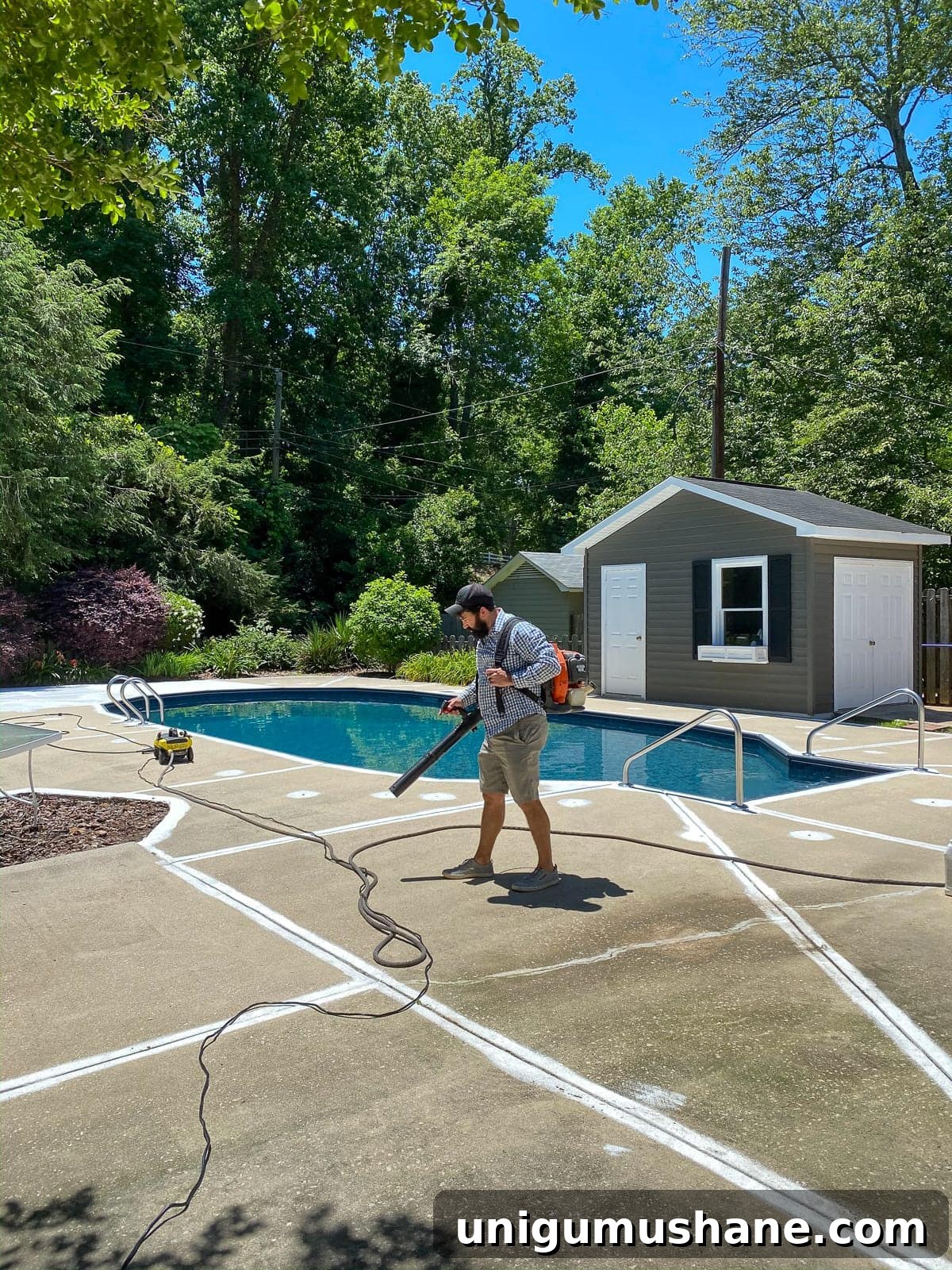 prepping a pool deck for painting by blowing off debris