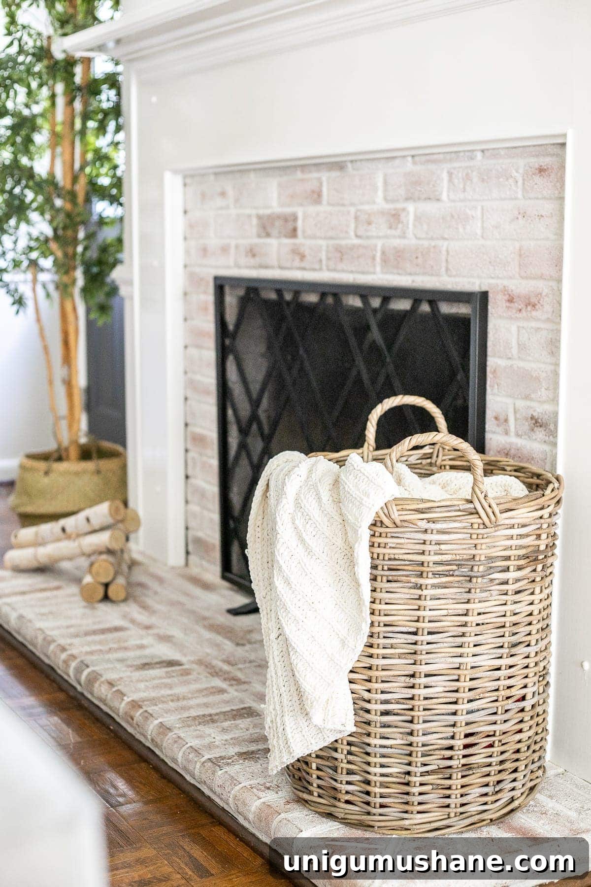 woven basket with cable knit throw blanket on limewashed brick fireplace
