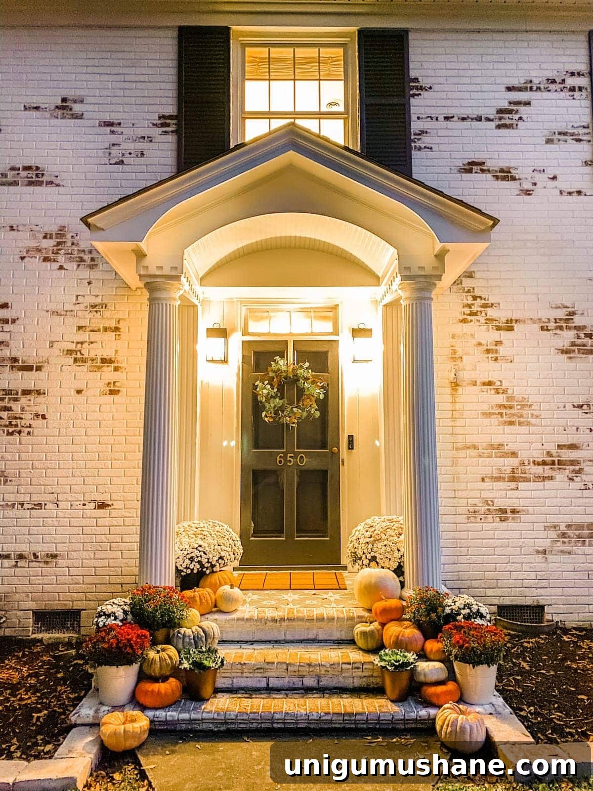 Colorful Fall Porch Stoop Decor for a Cozy Entryway 7 fall porch at night with pumpkins and mums and limewashed brick