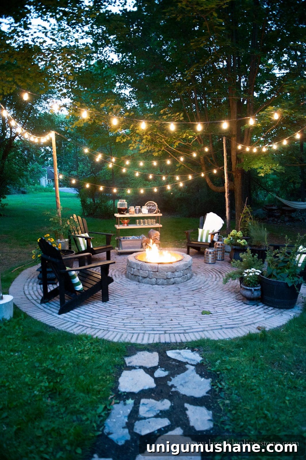 fire pit with string lights and stone walkway