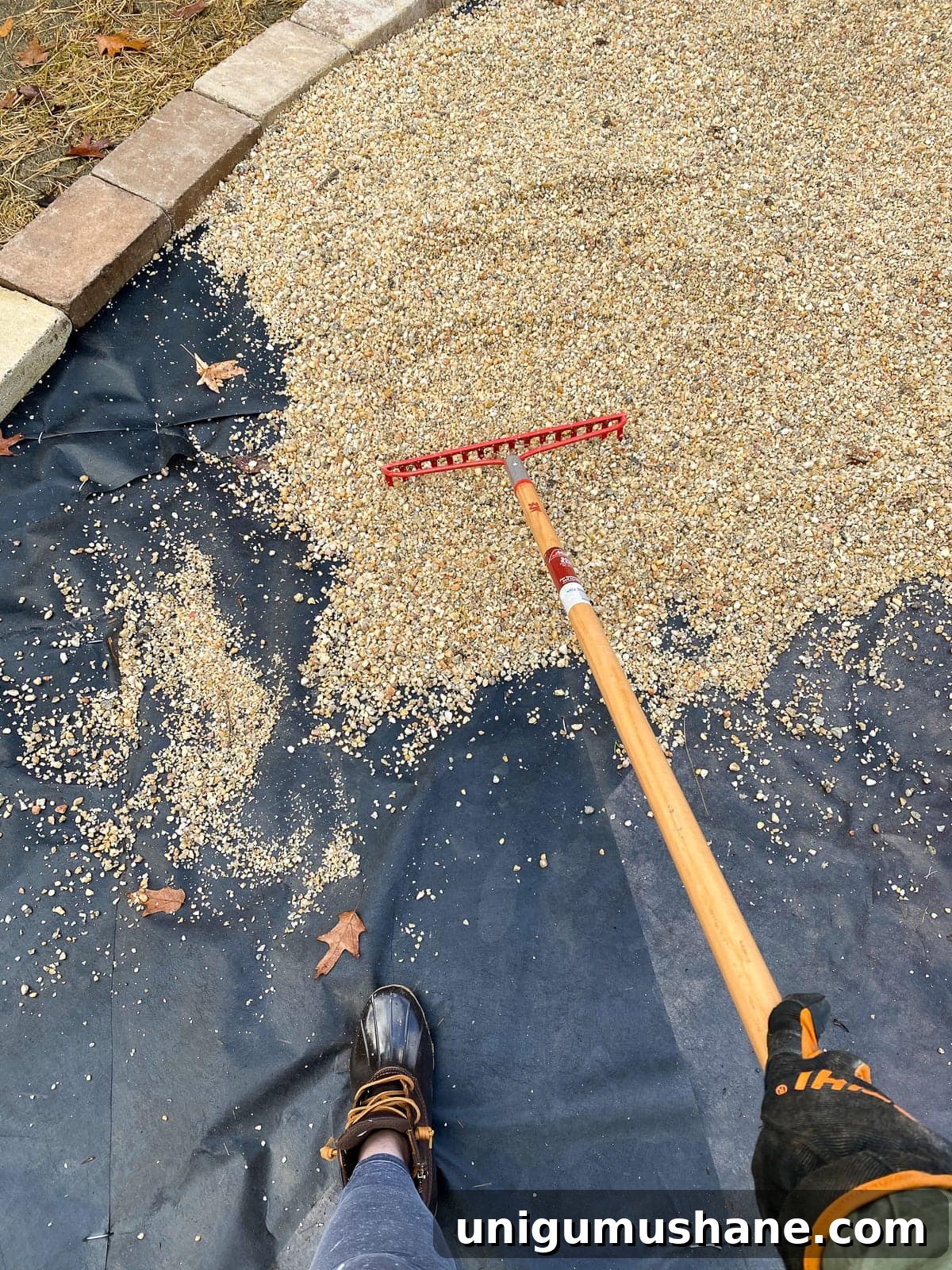 Build a Pea Gravel Backyard Fire Pit in a Weekend 14 Raking pea gravel on landscape fabric for a fire pit