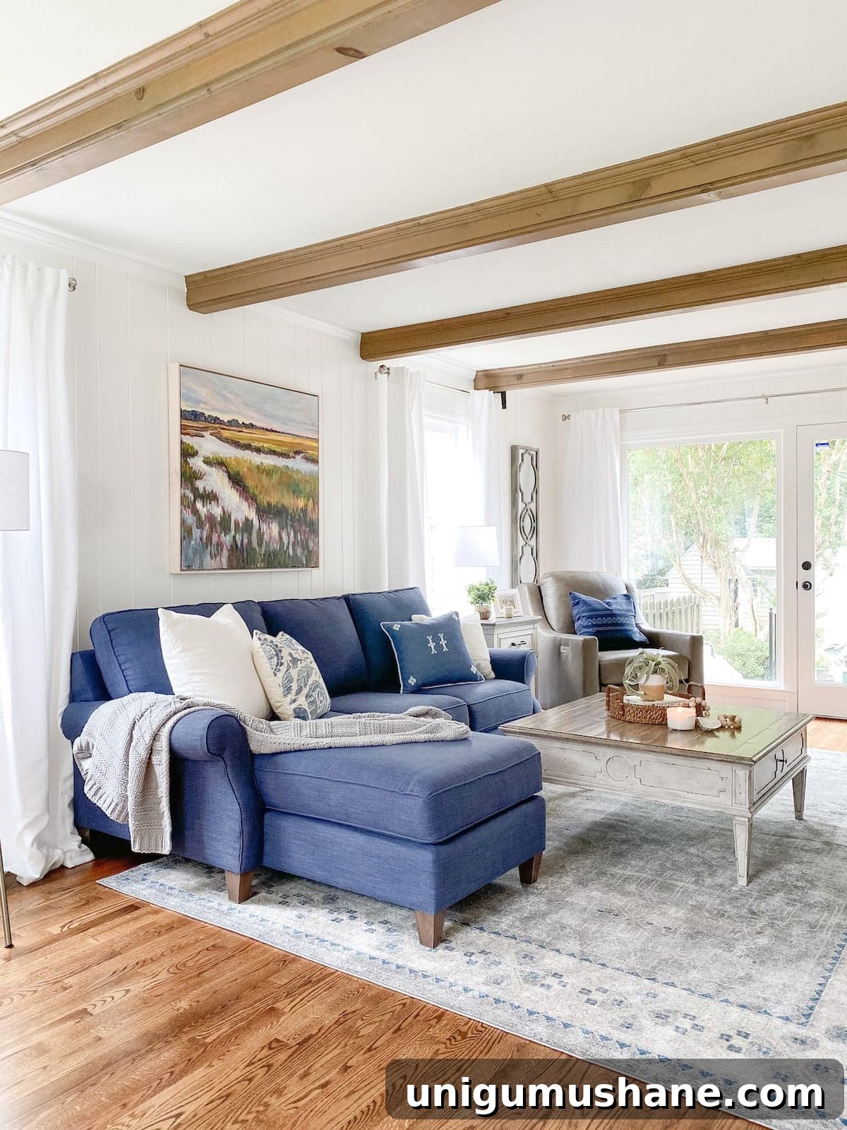 How to Choose the Perfect Rug: Size, Material and Style Tips 11 coastal living room with beams, navy sofa, rug, and weathered table