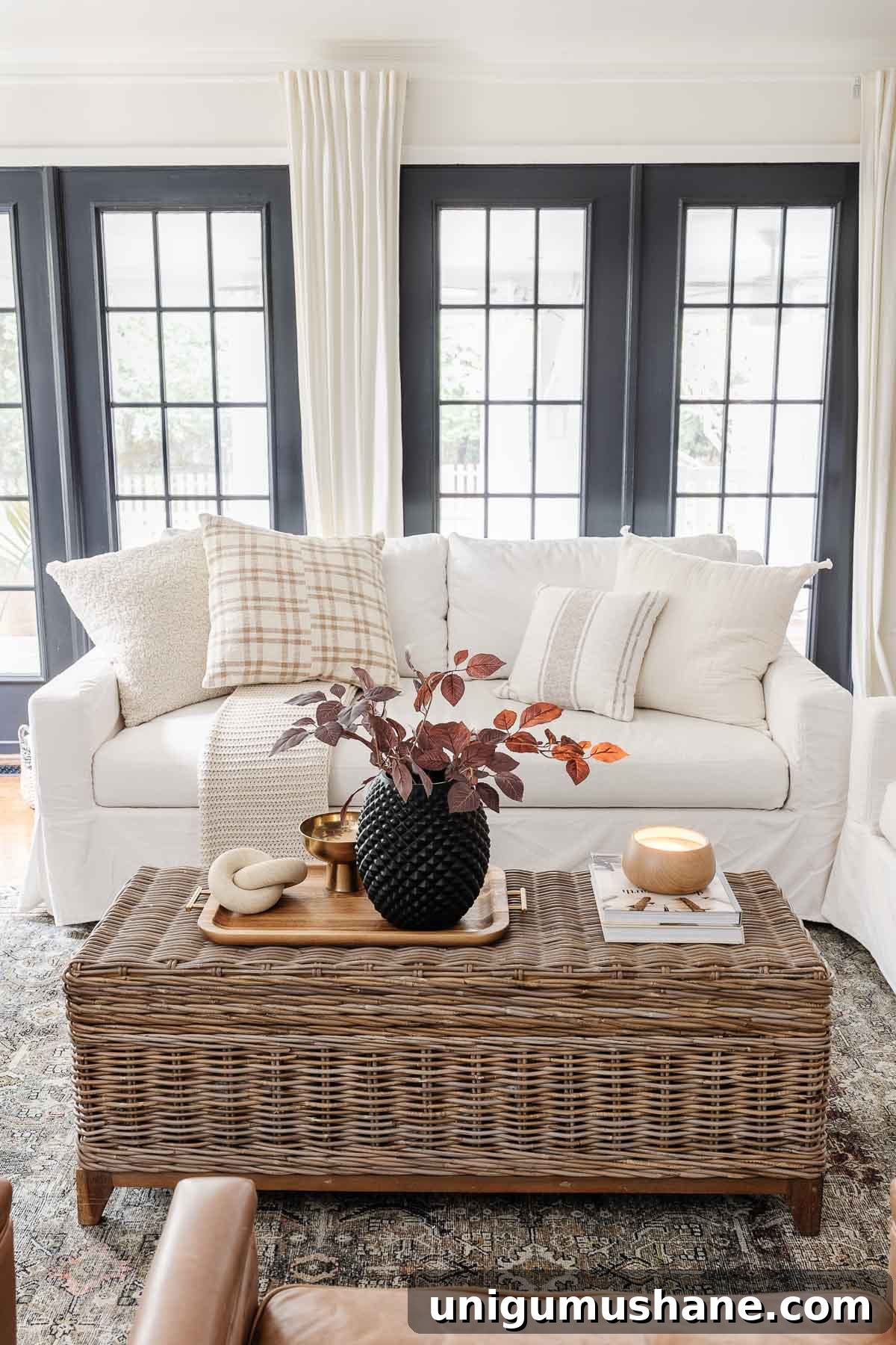 Coffee Table Decor Ideas with Styling Tips 3 coffee table decor ideas with rattan coffee table trunk, black vase with fall stems, wooden candle, coffee table books, wooden tray, brass bowl, and stone knot sculpture