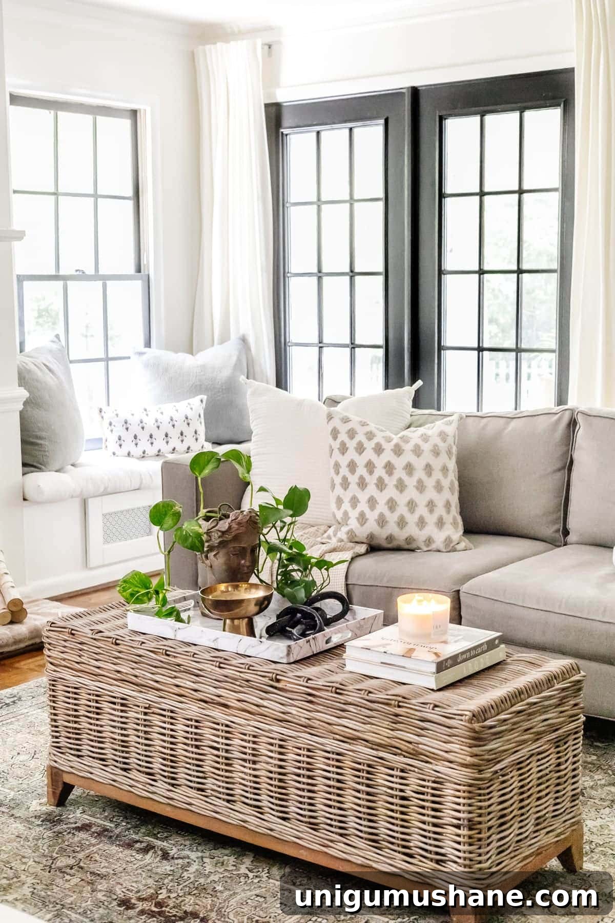 Coffee Table Decor Ideas with Styling Tips 4 rattan coffee table in a living room with black doors, bust planter, and marble tray