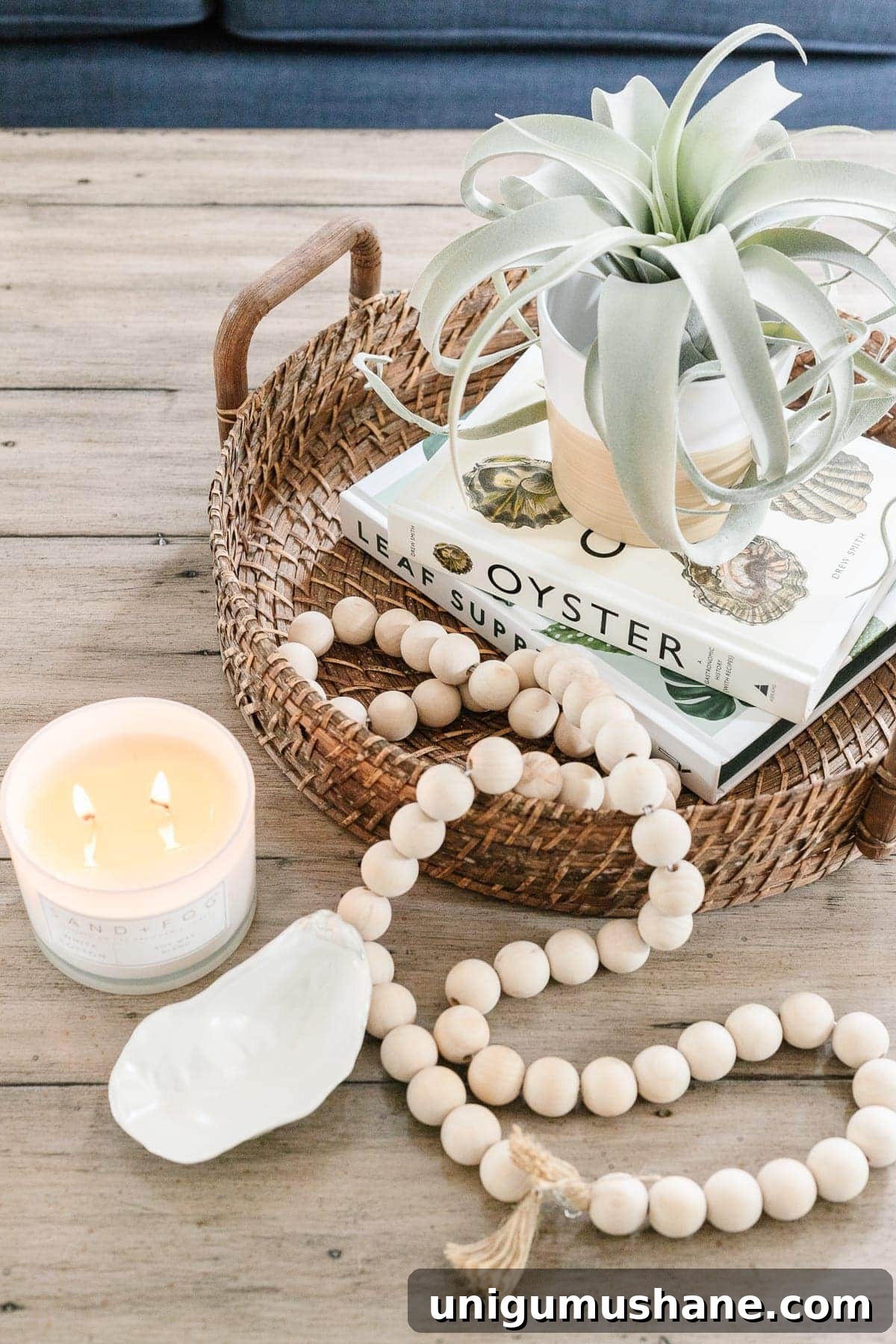 Coffee Table Decor Ideas with Styling Tips 5 coastal style coffee table decor with rattan tray, wooden beads, coffee table books, candle and air plant