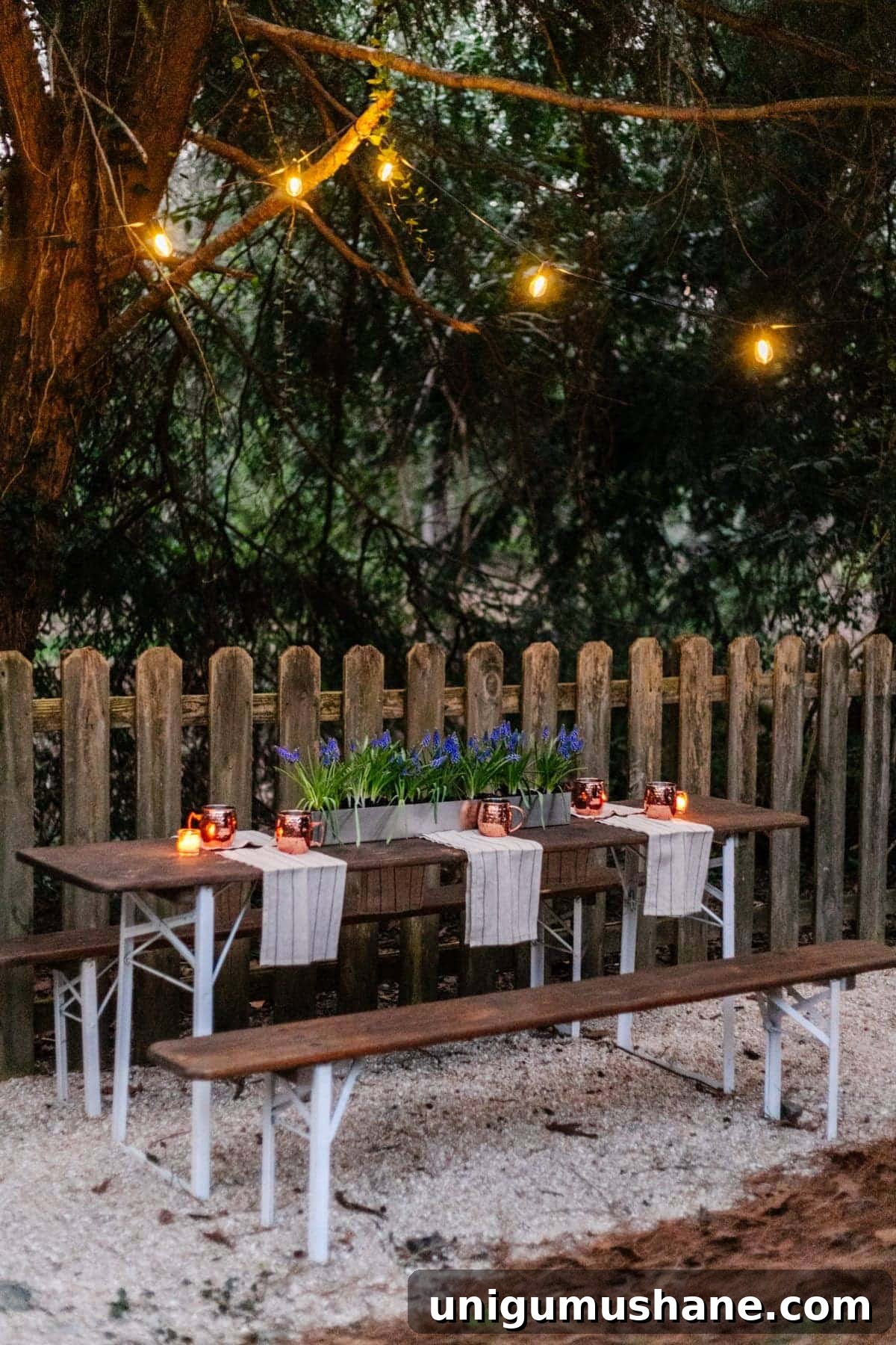 DIY Beer Garden: Transform Your Neglected Backyard 8 hanging solar string lights in trees above a folding table to make a backyard beer garden dining area