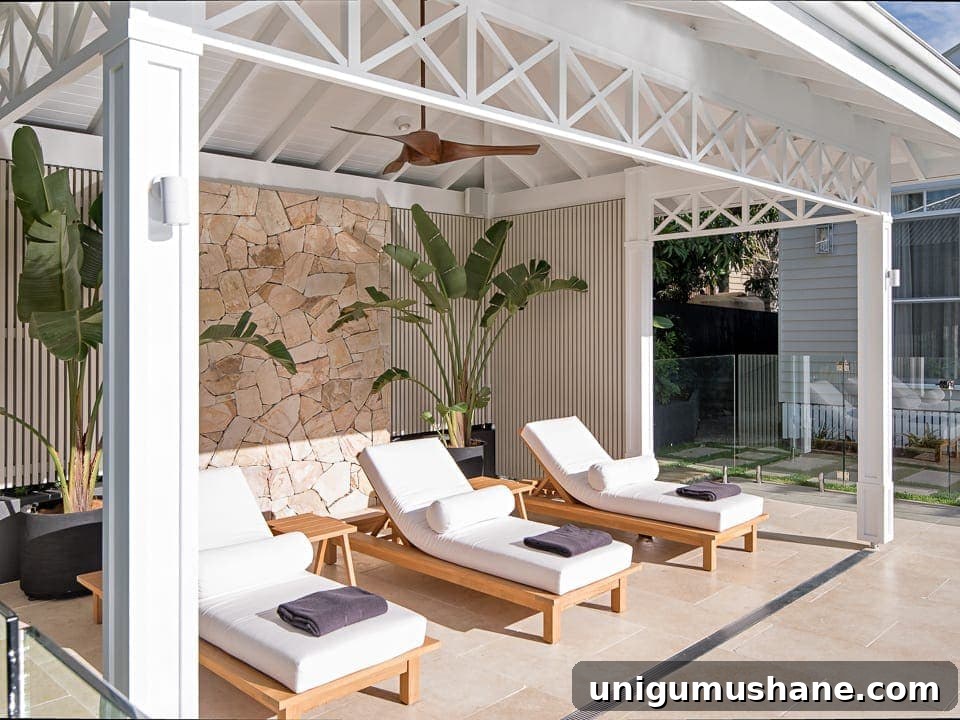 7 Pool Cabana Ideas for Your Next Backyard Project 3 white cabana with outdoor lounge chairs and stone wall
