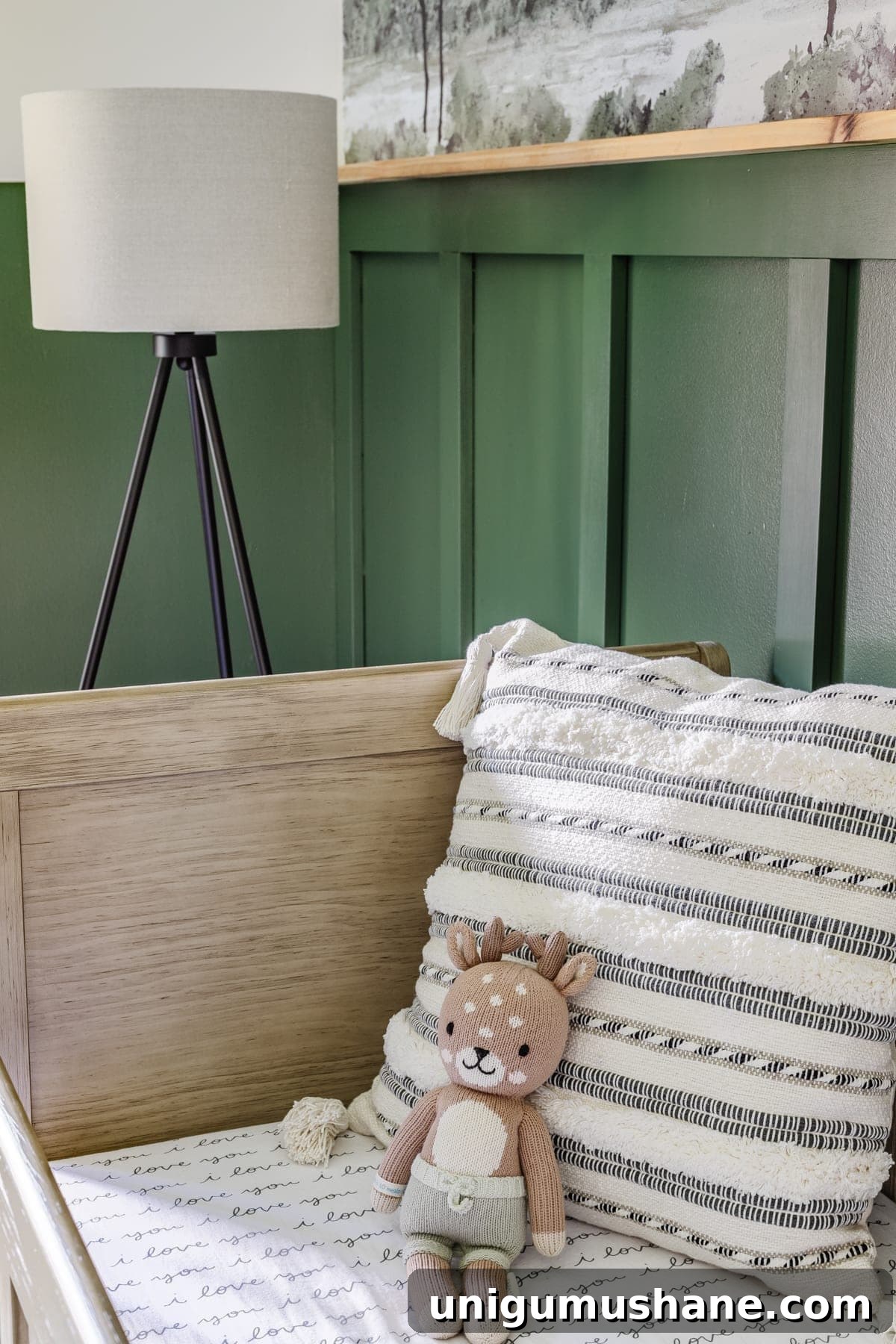baby nursery with woodland theme - floor lamp and pillow with natural wood crib
