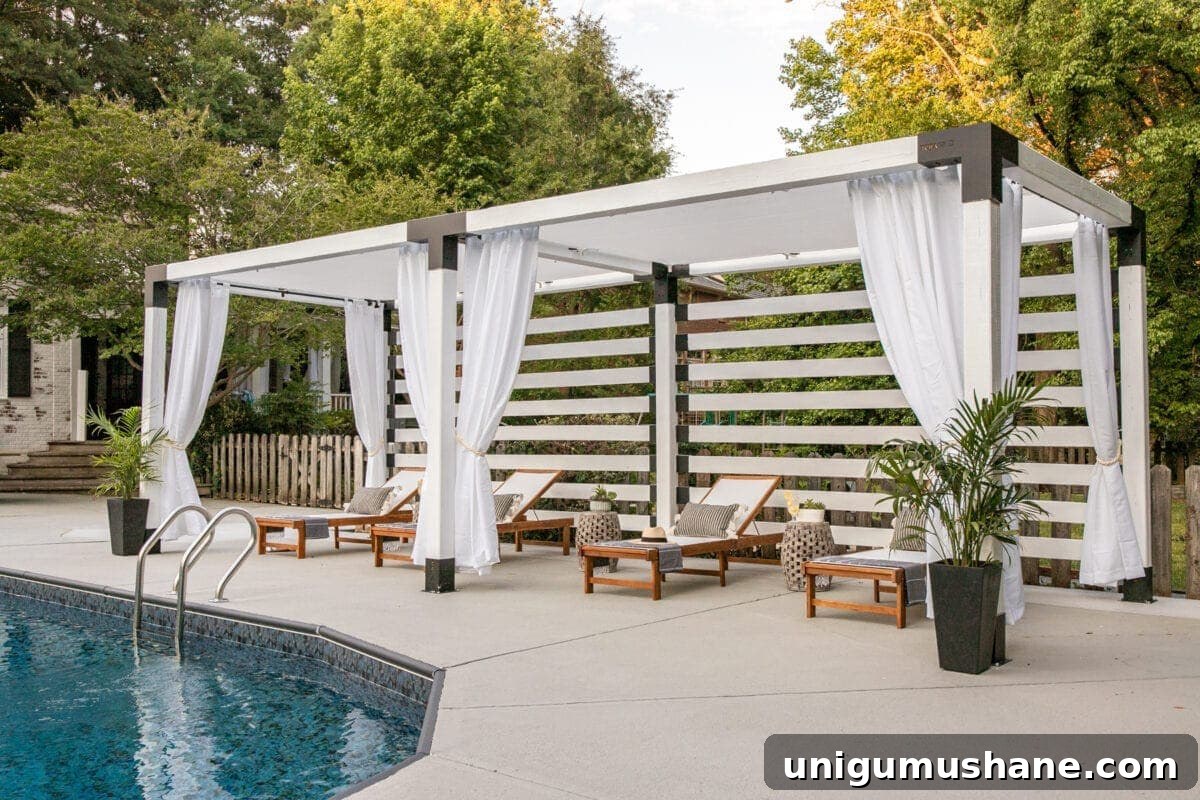 white DIY pergola cabana with outdoor curtains and lounge chairs