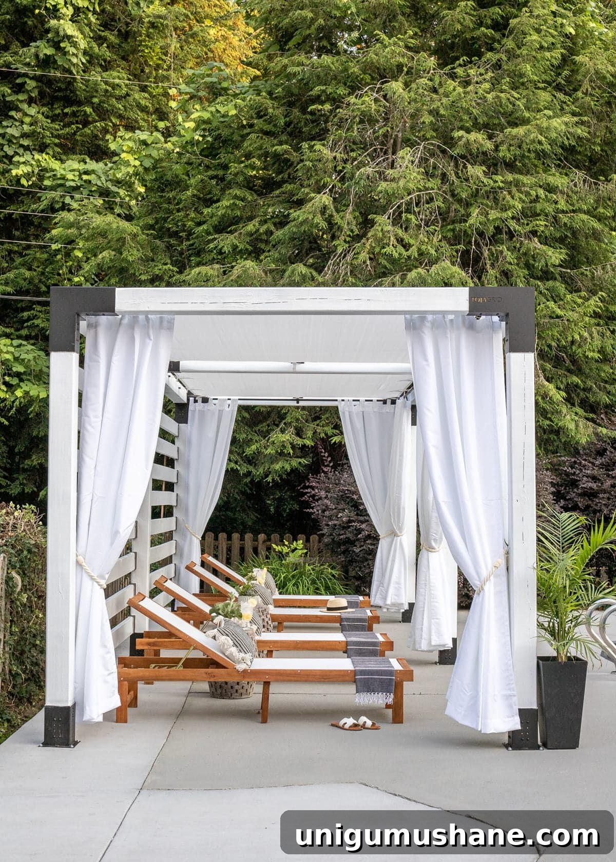 white DIY pergola cabana with outdoor curtains and lounge chairs