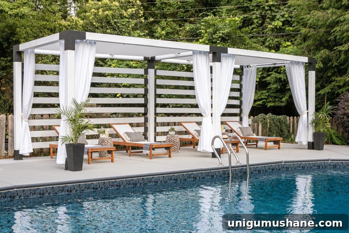 white DIY pergola cabana with outdoor curtains and lounge chairs