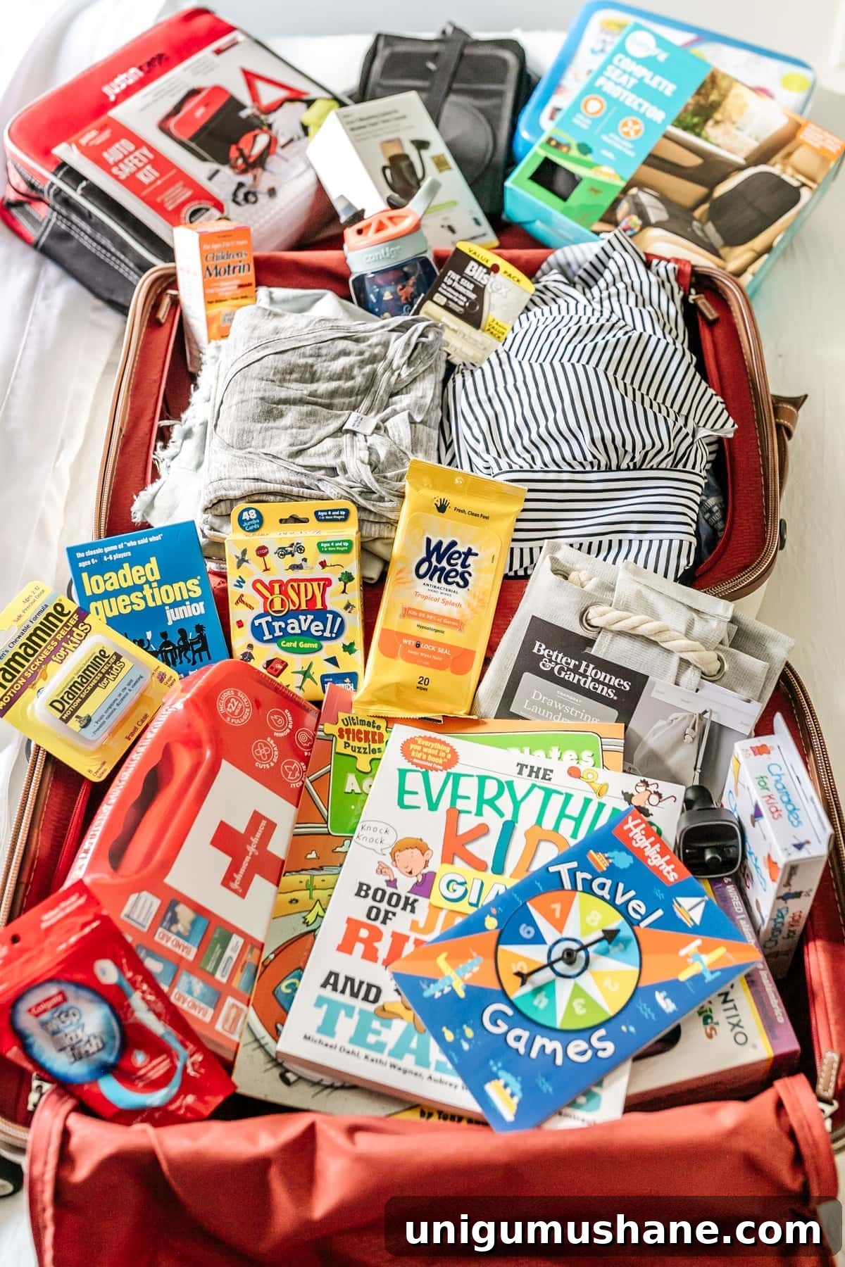 Printable Road Trip Checklist with Packing Essentials 3 suitcase packed with travel essentials like travel games, first aid kit, wet wipes, Dramamine, and car organizers