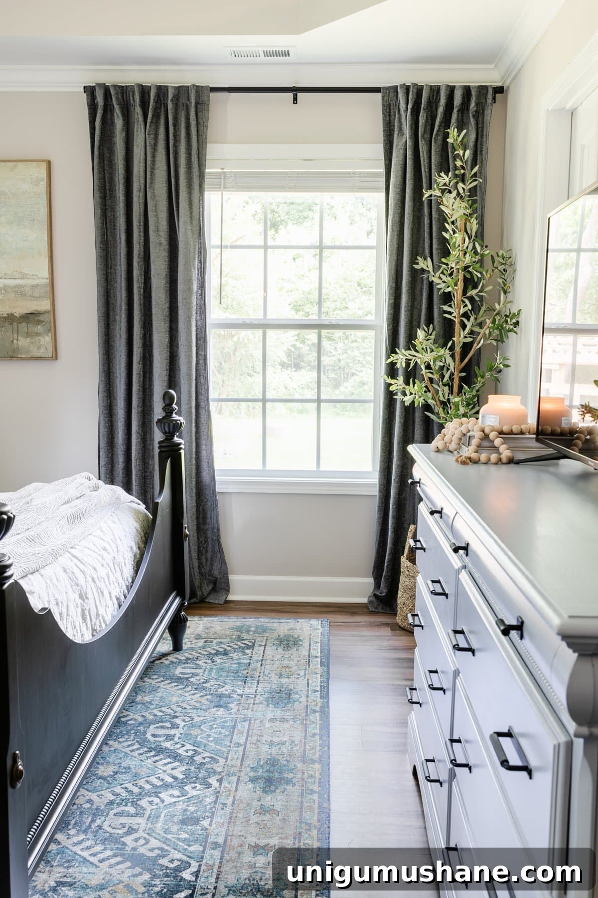curtain panels hung high and wide in a small bedroom to make it look bigger