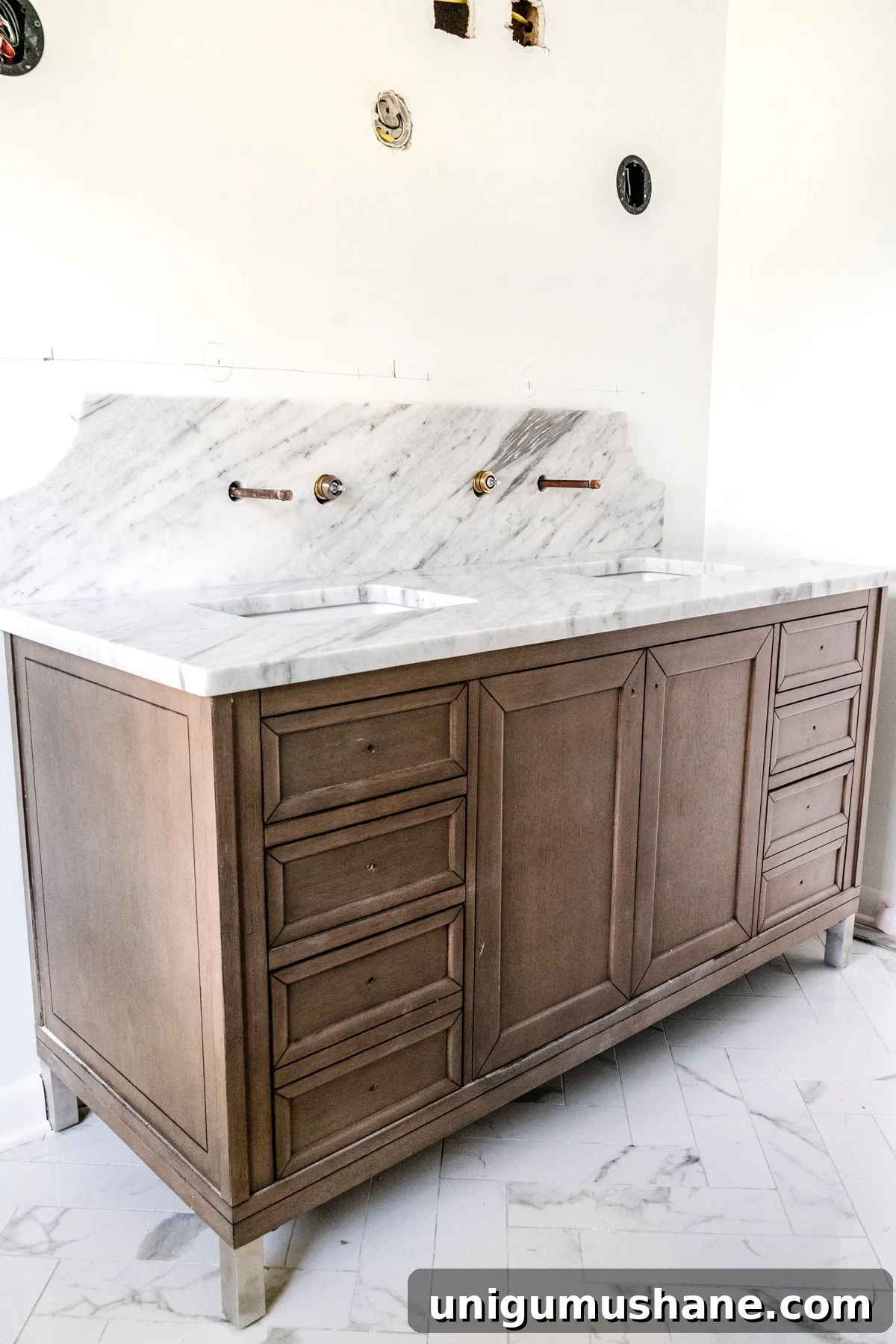 wood vanity with scalloped marble backsplash and herringbone tile