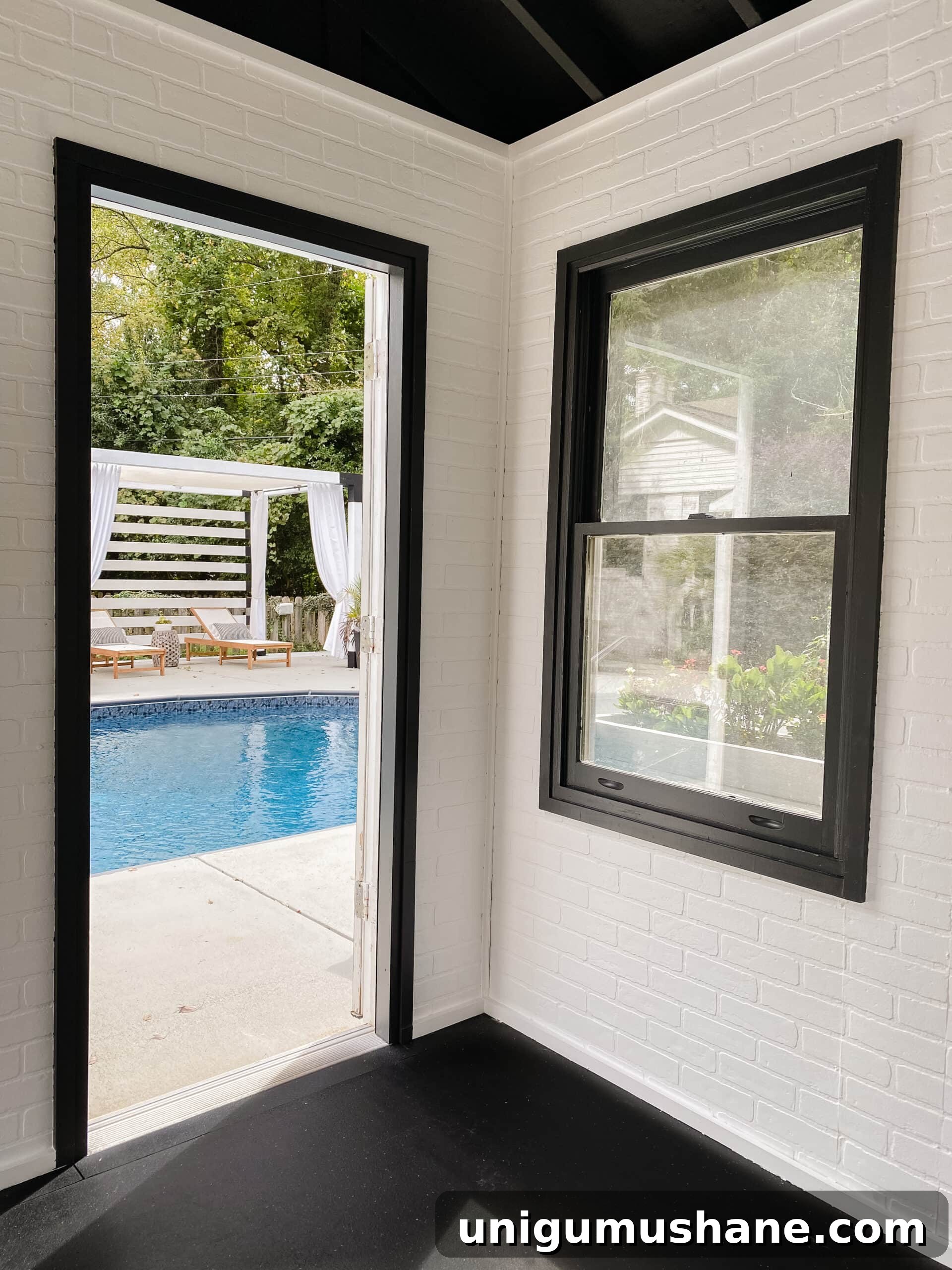 white brick walls and black trim in a poolside home gym