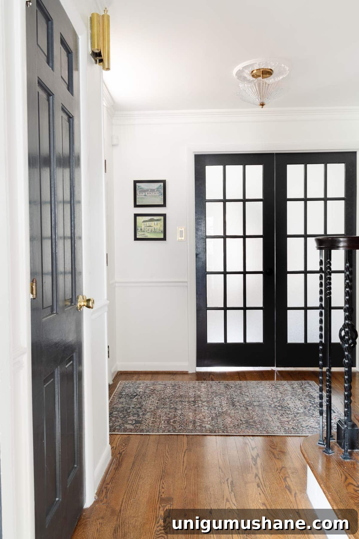 house portrait art beside front door in foyer with double French doors leading to home office