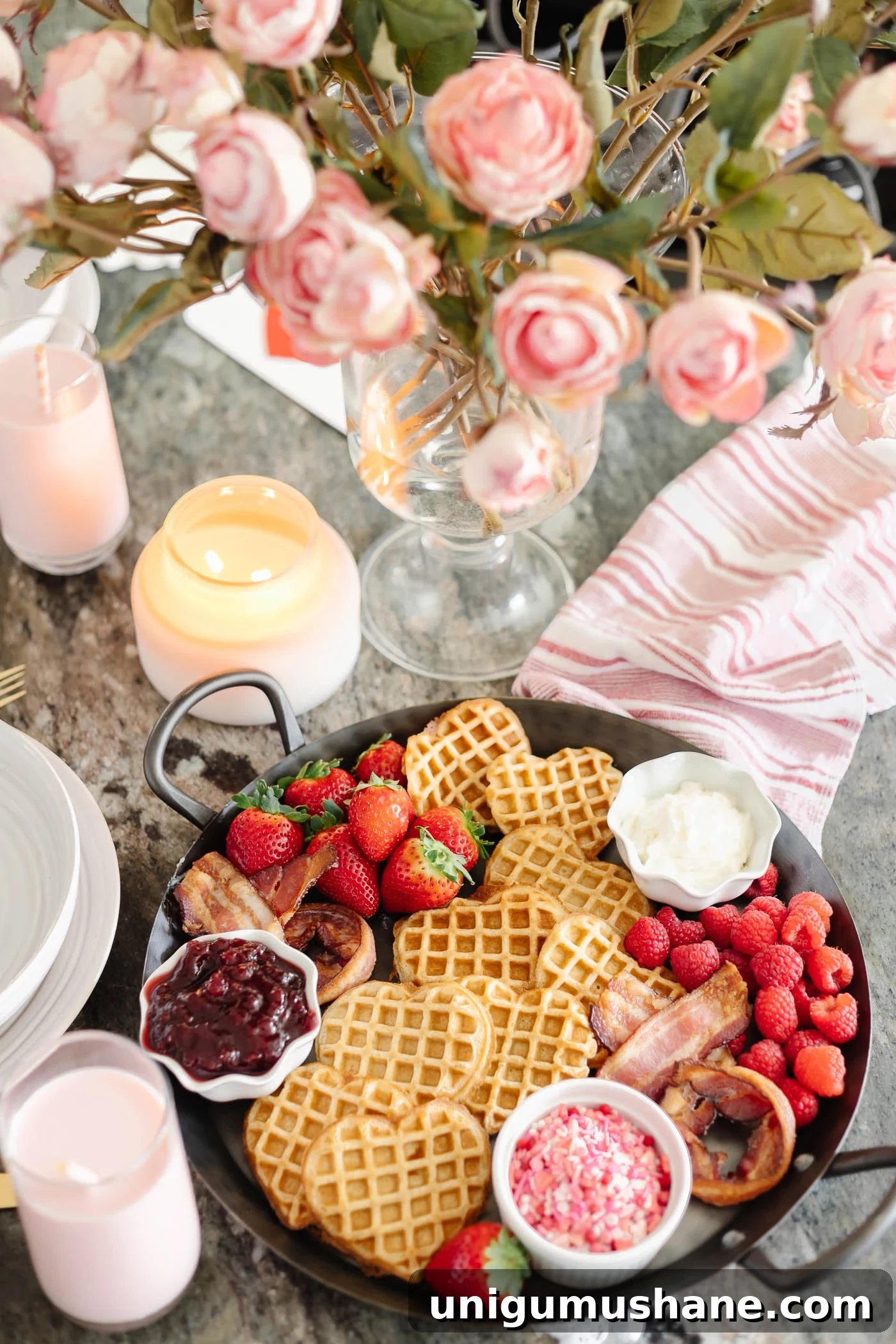 Valentine's Day Breakfast Charcuterie Board for Two 5 Valentine's Day breakfast charcuterie board with heart shaped waffles, XO bacon, berries, and condiments with flowers and candles