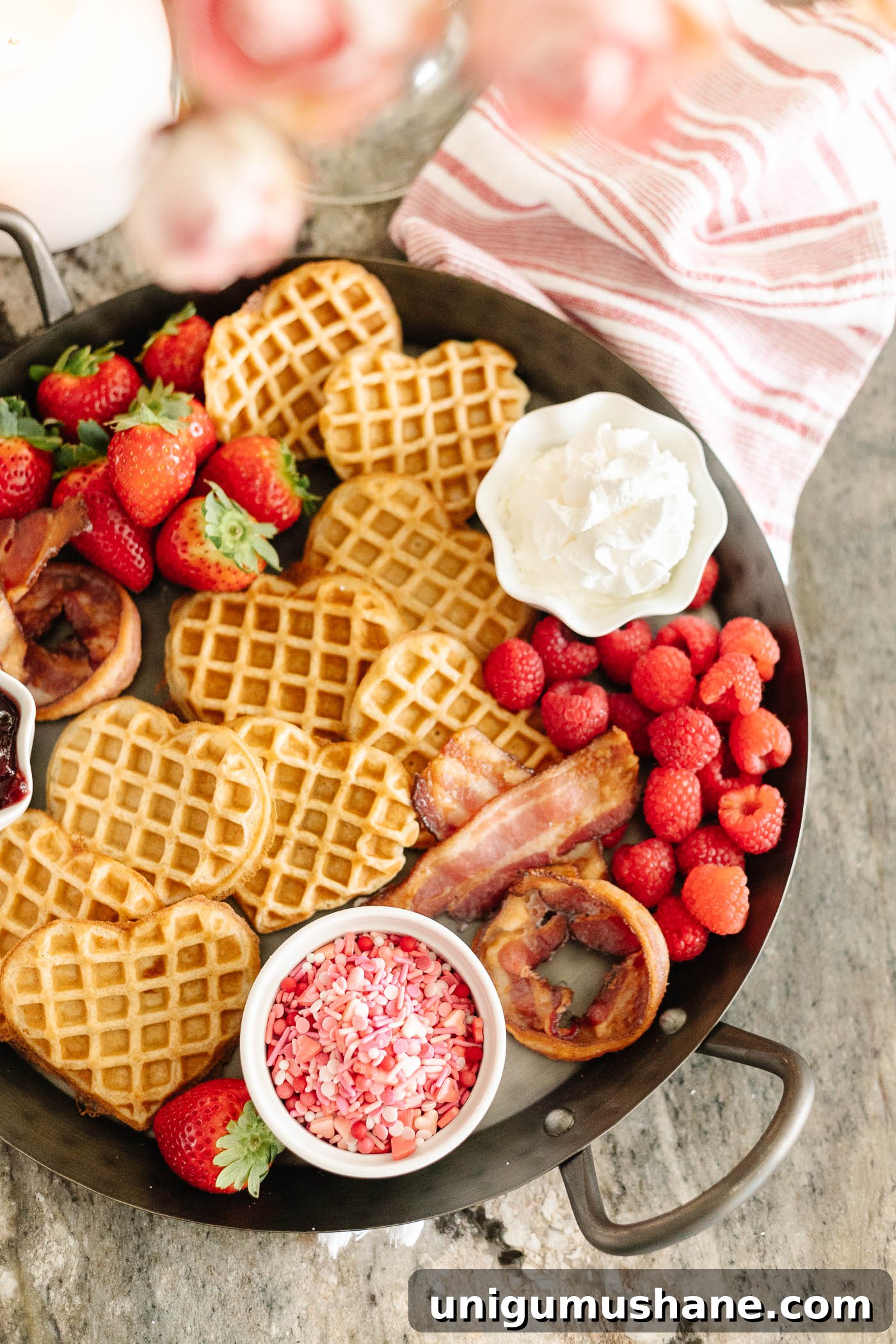 Valentine's Day Breakfast Charcuterie Board for Two 6 Valentine's Day breakfast charcuterie board with heart shaped waffles, XO bacon, berries, and condiments on a tray