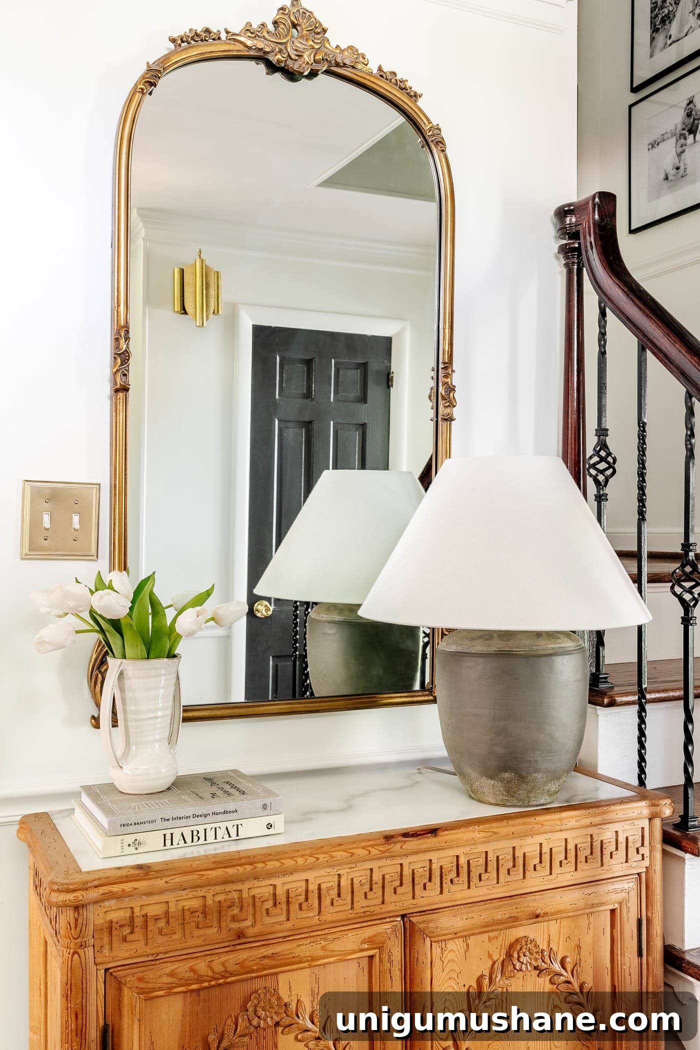 Style an Entry Table Like a Pro: Step-by-Step Guide 7 adding a stack of books underneath a vase of flowers as risers for height in decorating a foyer table