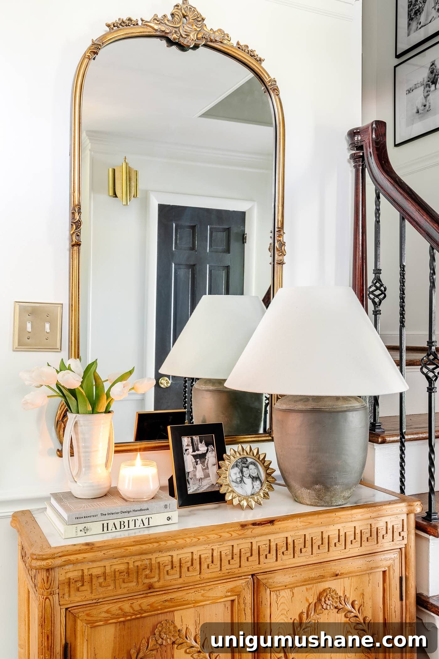 antique gold mirror in an entryway above foyer chest