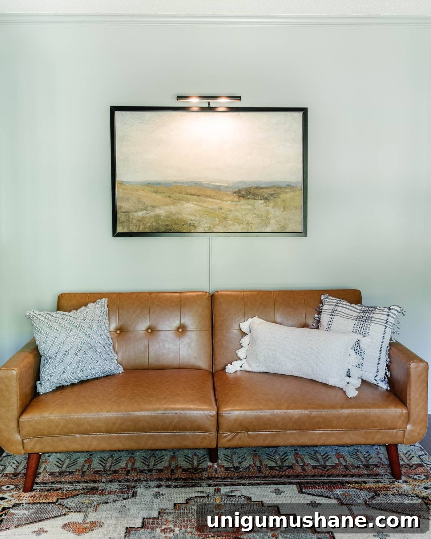 8 Lounge-Style Home Office Ideas to Boost Productivity 10 office lounge with a faux leather futon, art, and picture light