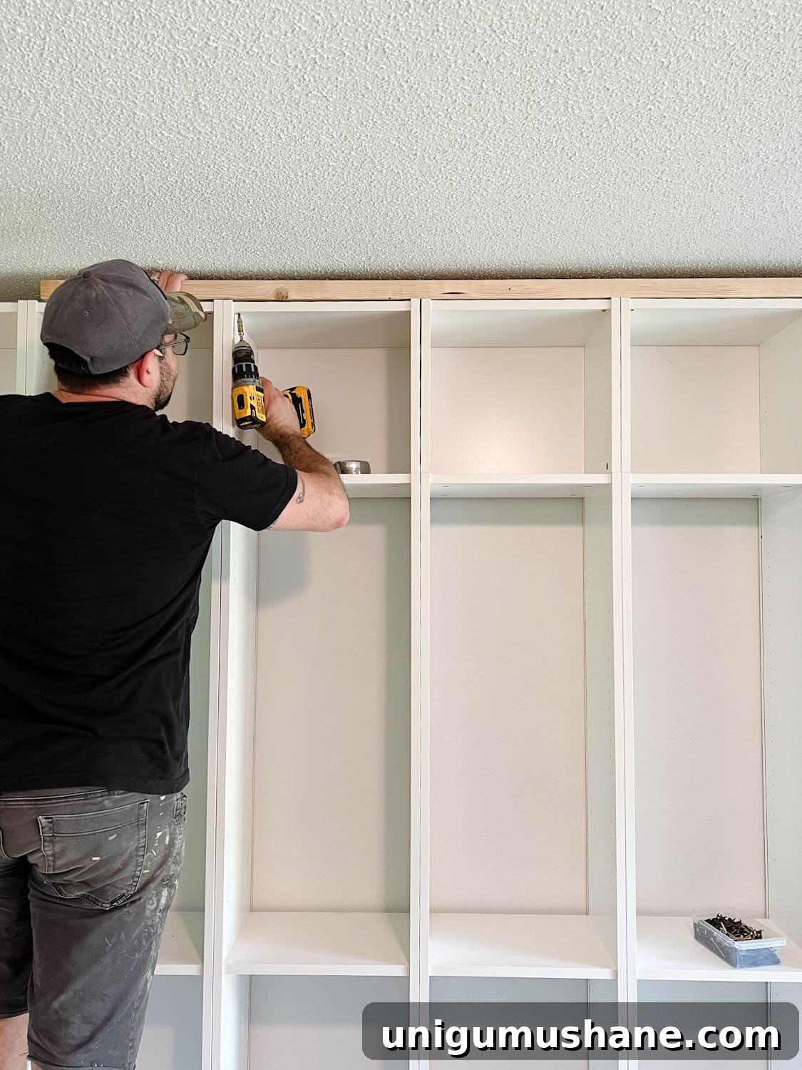 Convert IKEA Billy Bookcases into Built-In Bookshelves 14 adding a 2x4 board to the top of bookcases to fill the gap below the ceiling for DIY built in bookshelves