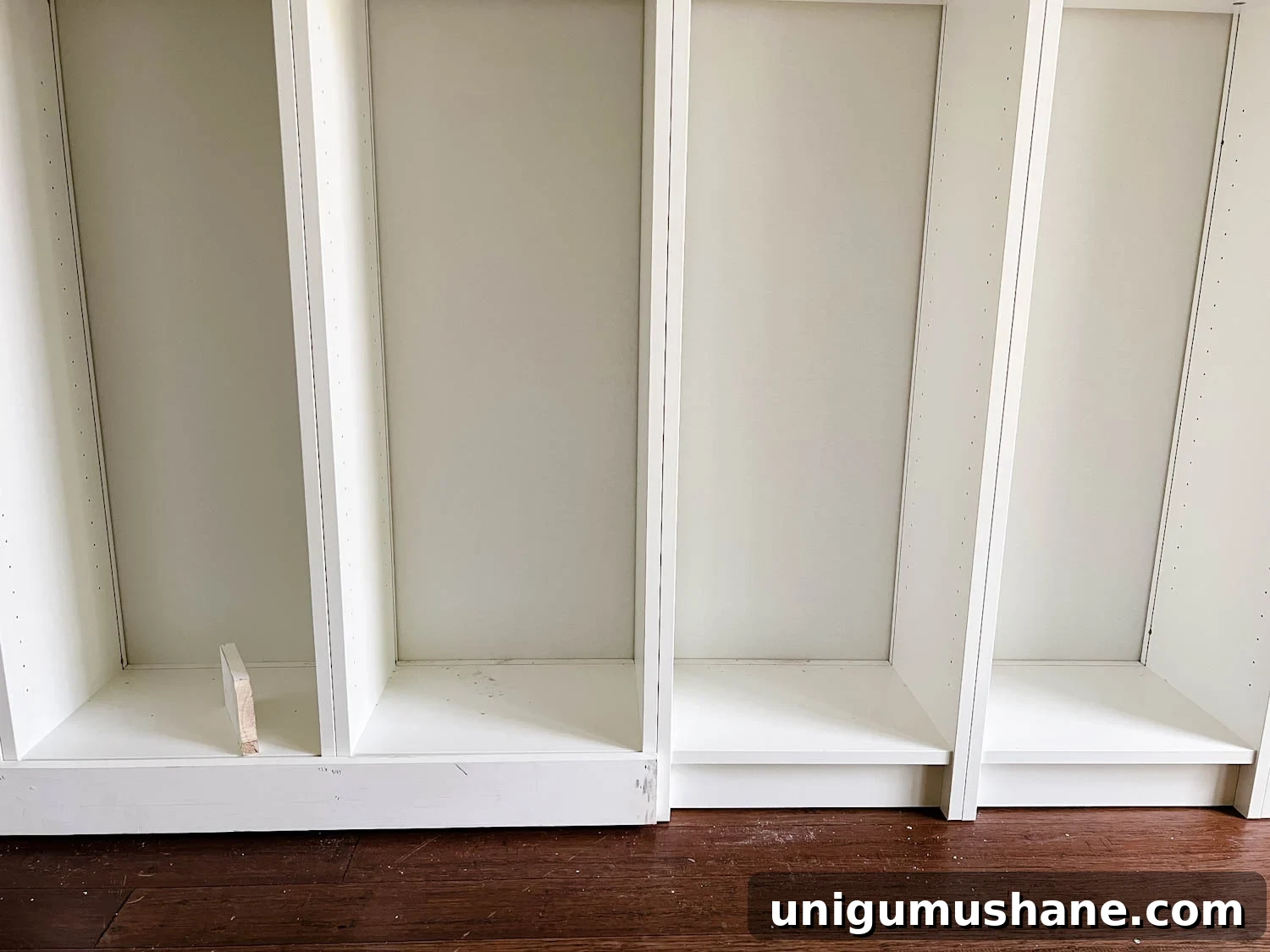 Convert IKEA Billy Bookcases into Built-In Bookshelves 15 adding 1x4 boards to the bottom of bookcases to make them look flush for DIY built in bookshelves