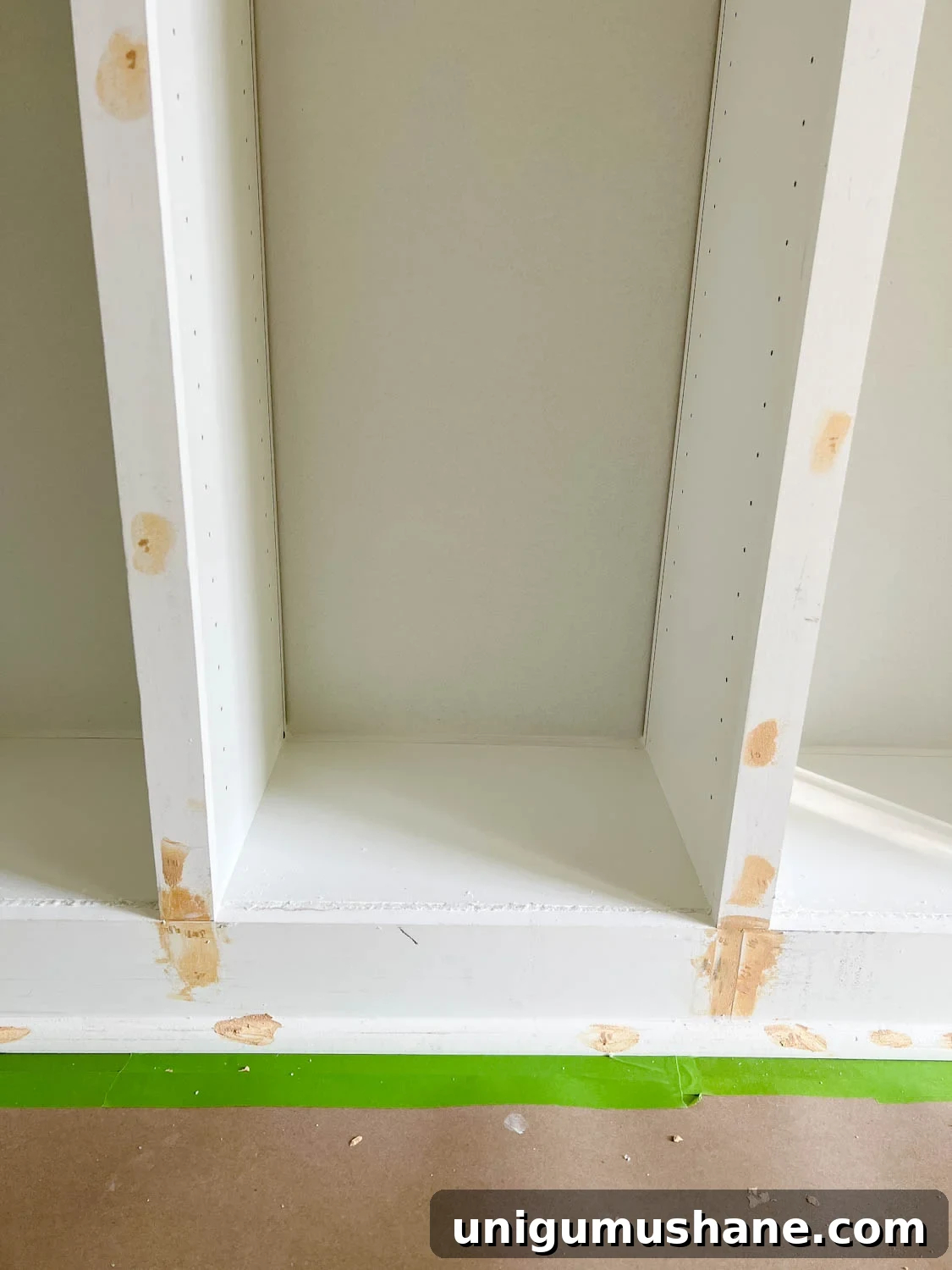 Convert IKEA Billy Bookcases into Built-In Bookshelves 22 wood filler, caulk, and Loctite foam covering gaps, cracks, and nail holes