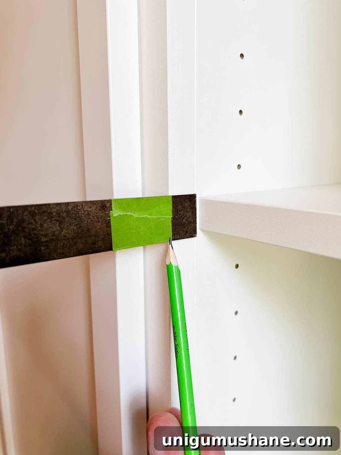 Convert IKEA Billy Bookcases into Built-In Bookshelves 27 using tape on a combination square to mark new depth of hinge holes