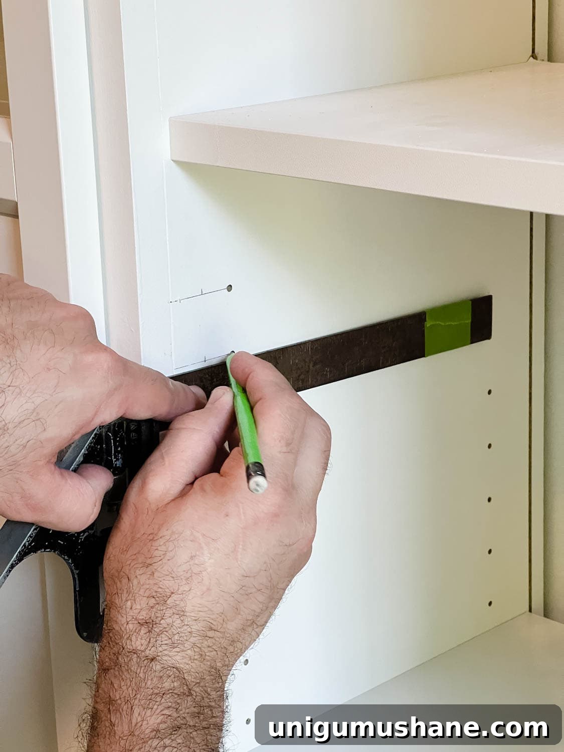 Convert IKEA Billy Bookcases into Built-In Bookshelves 29 marking new holes to drill for door hinges on shelves