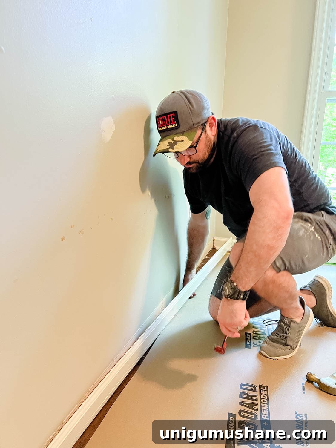 Convert IKEA Billy Bookcases into Built-In Bookshelves 4 removing a baseboard from a wall using a pry bar and hammer